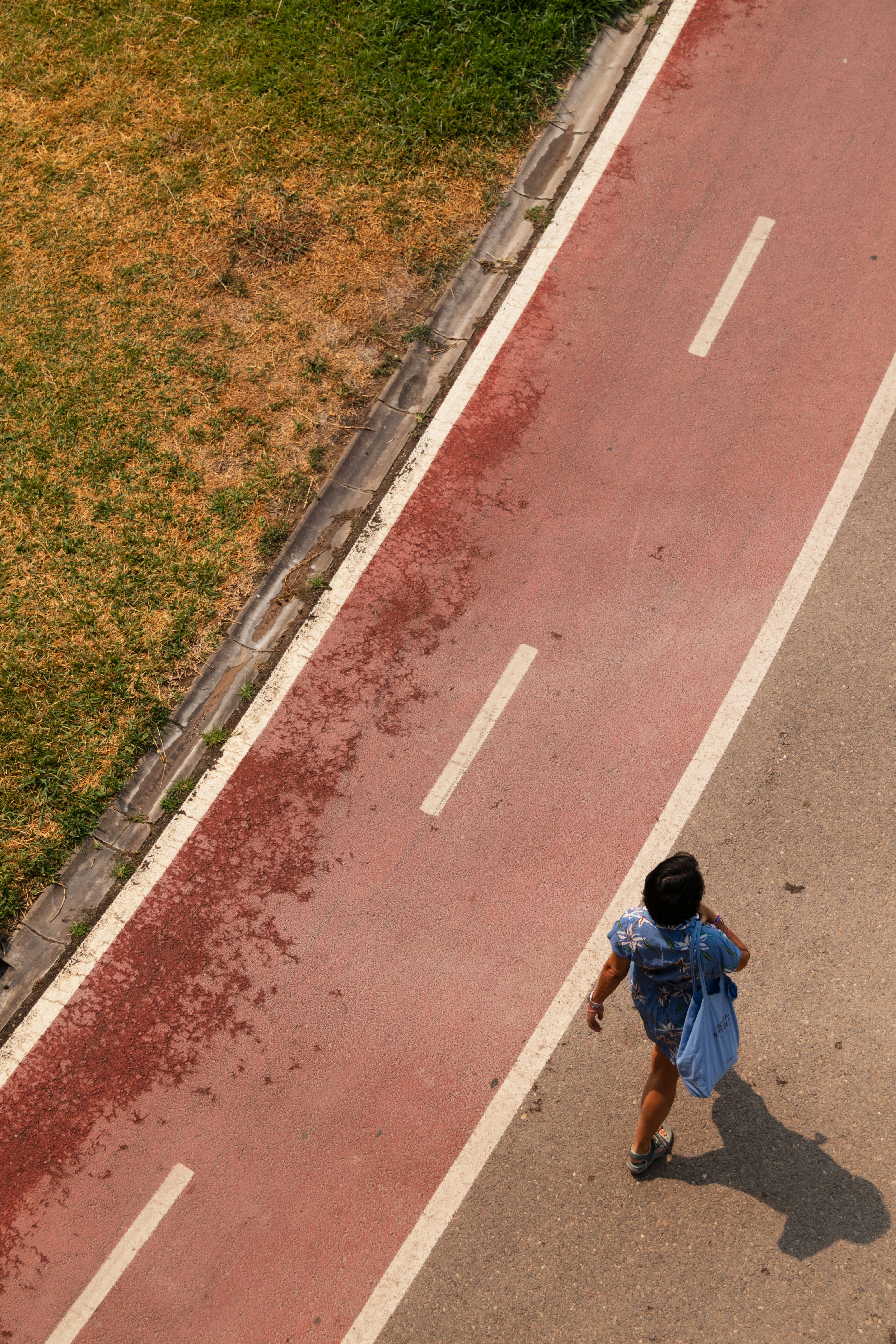 Person walking on a red path with white lines photo – Free Travel Image ...