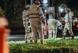 Construction workers in reflective gear working at night.