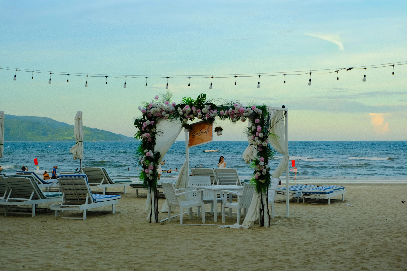 A wedding arch on a sandy beach with the ocean behind