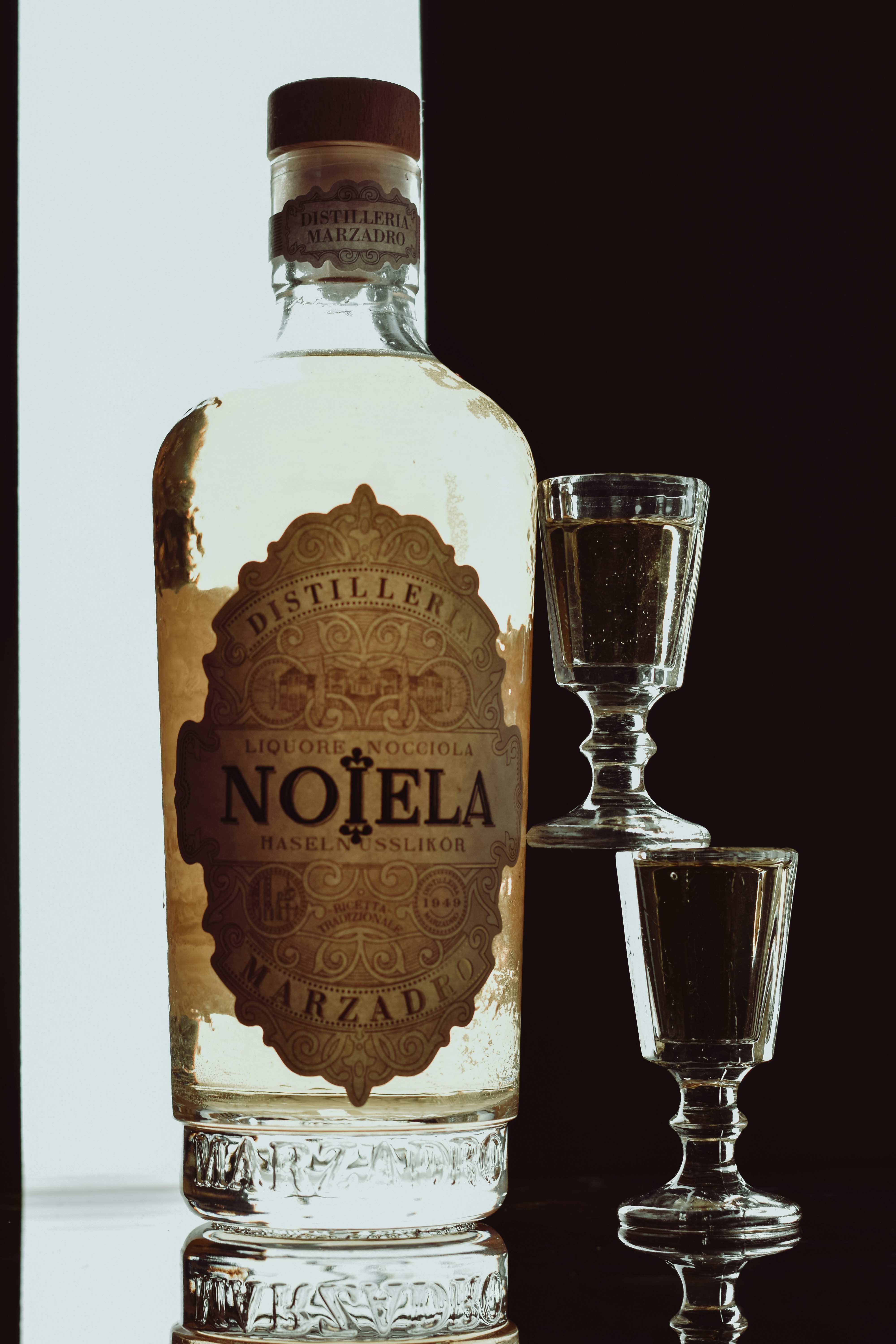 Bottle of nojela marzadro liqueur with two glasses