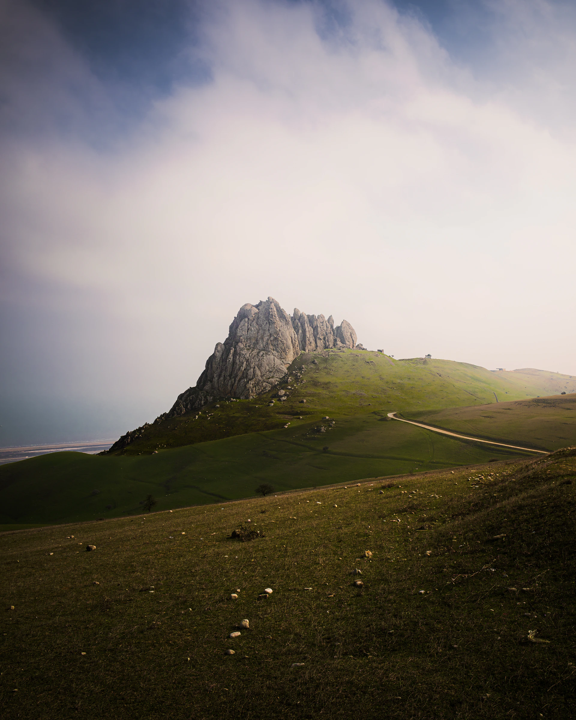 Rugged mountain peak on a green grassy hill