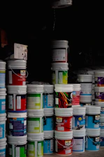 Stack of colorful paint buckets in a dark room