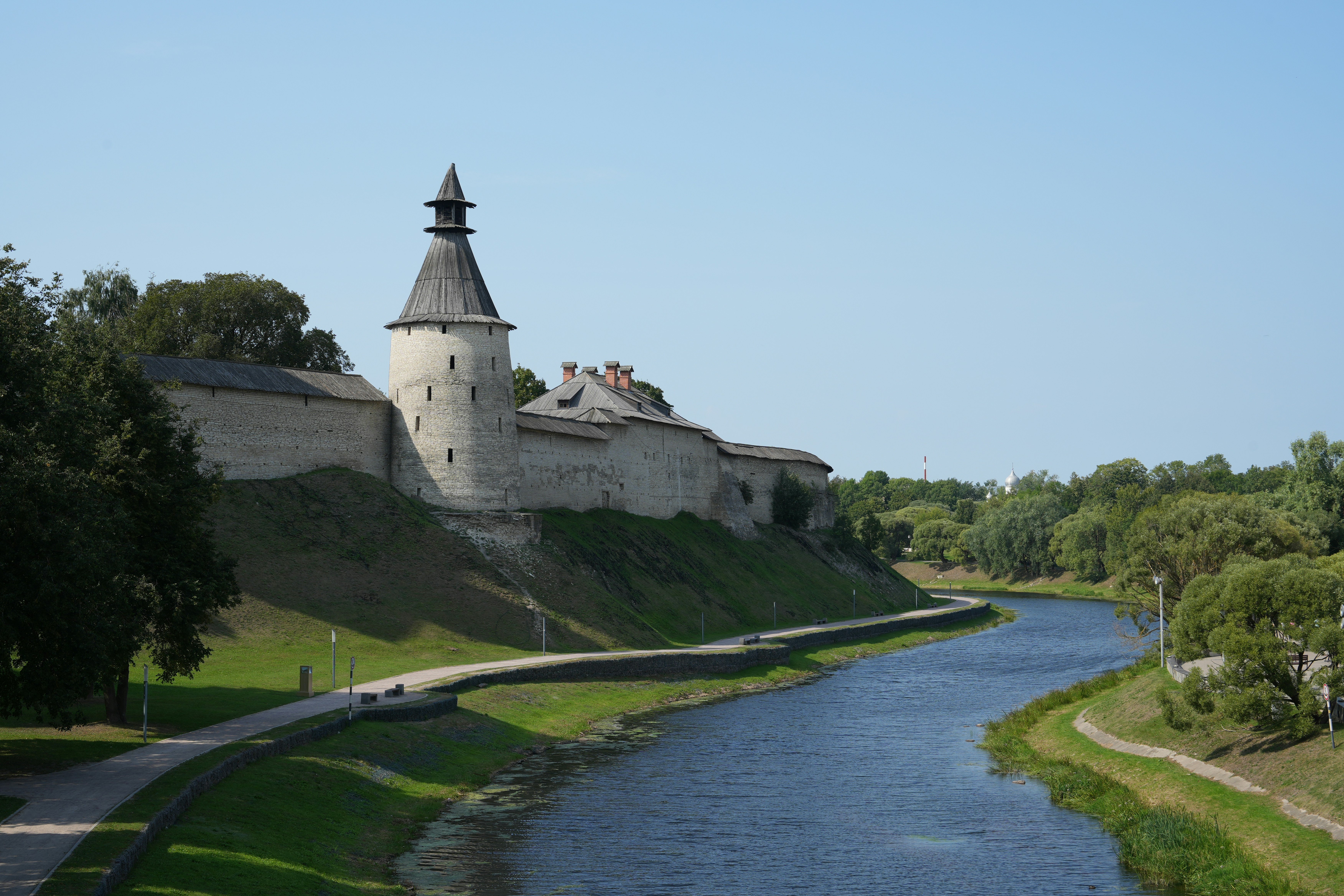 Stone fortress walls and tower beside a river