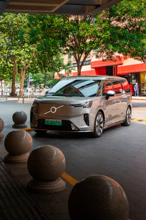 Modern silver volvo suv parked outdoors on city street.