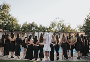 Group of women in black dresses by the pool