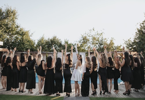 Bride and bridesmaids celebrating with raised arms