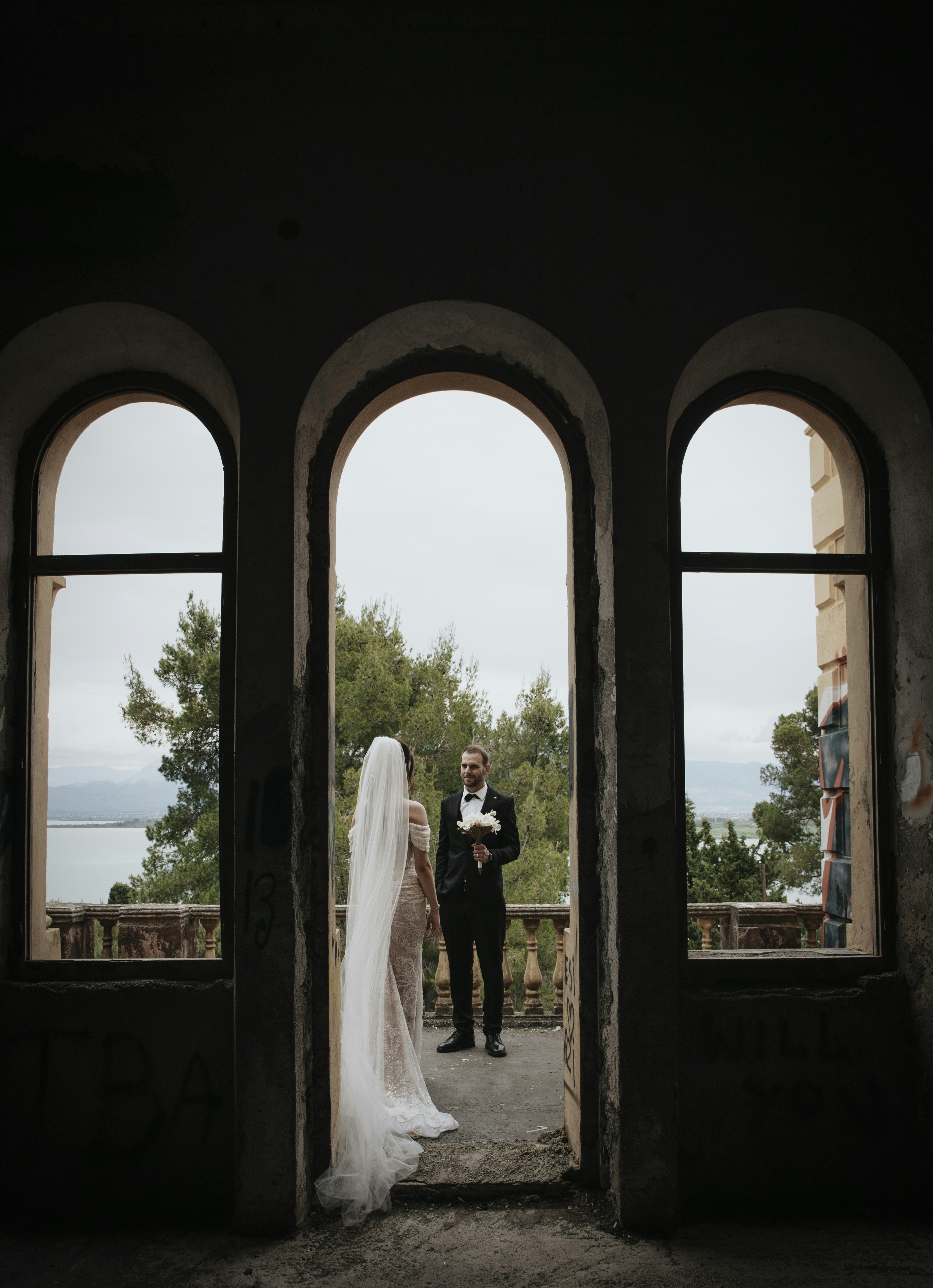Bride and groom standing in arched doorway with view