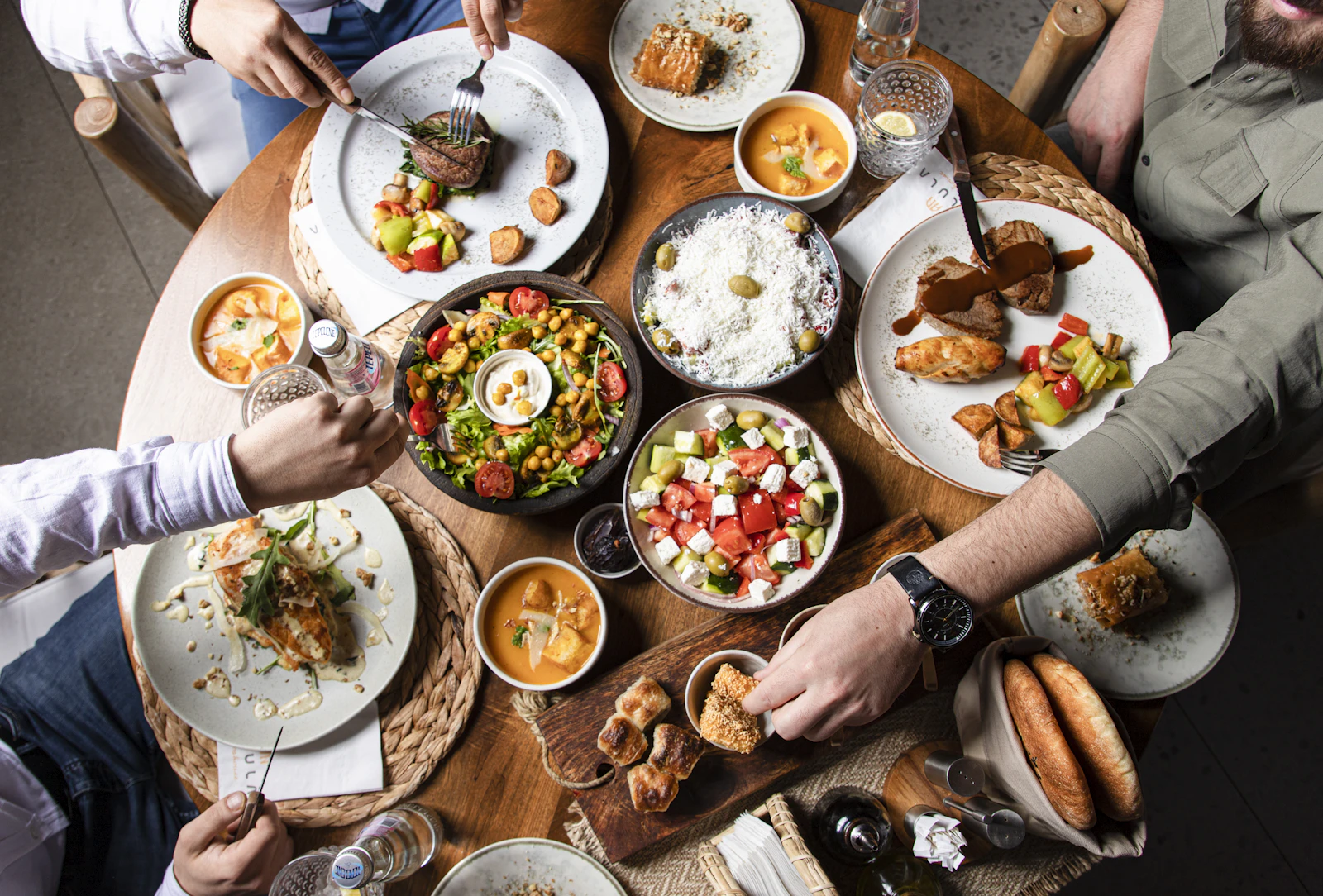 A shared lunch table seen from above, several people eating together