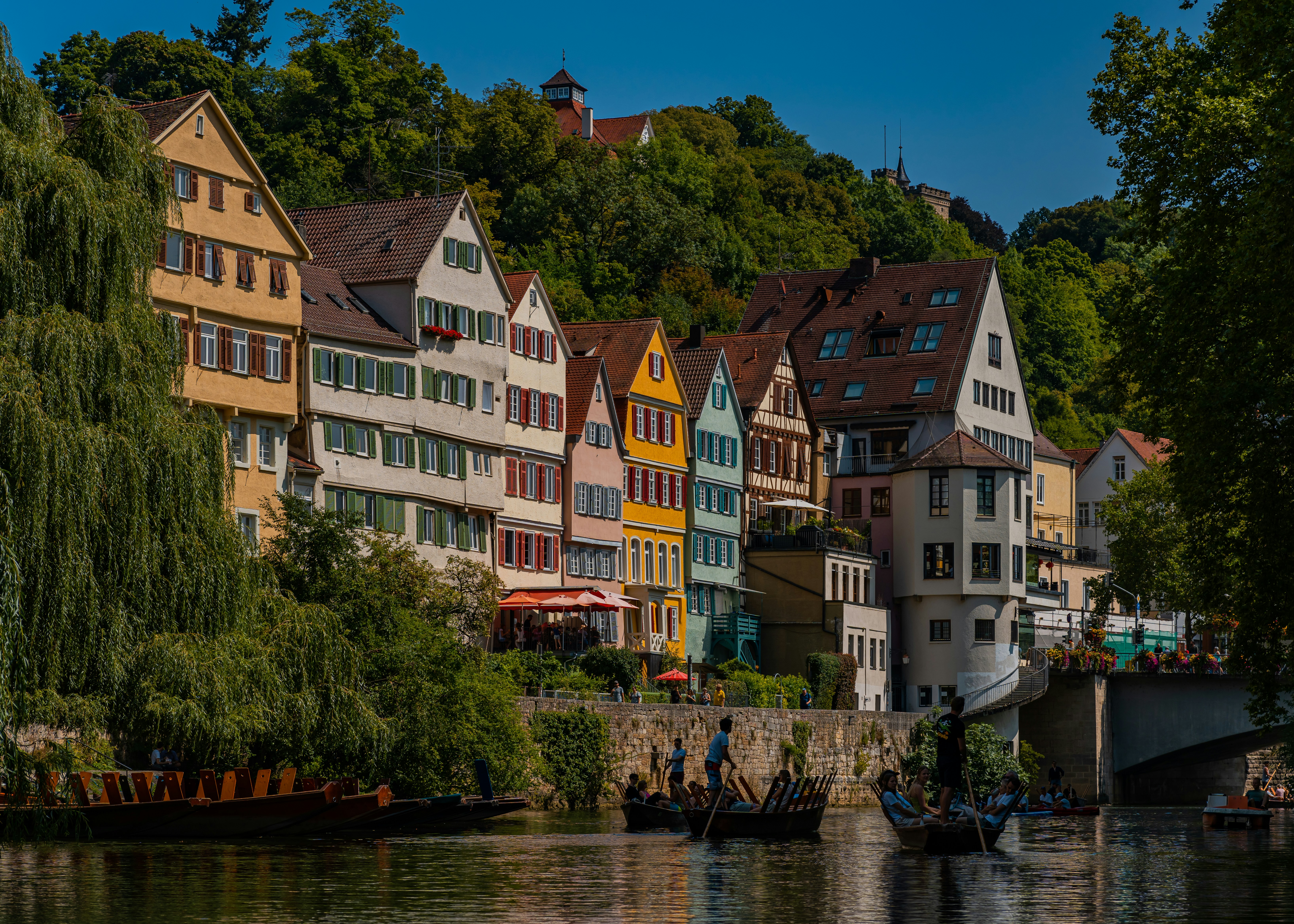 Colorful historic buildings line a river with boats.