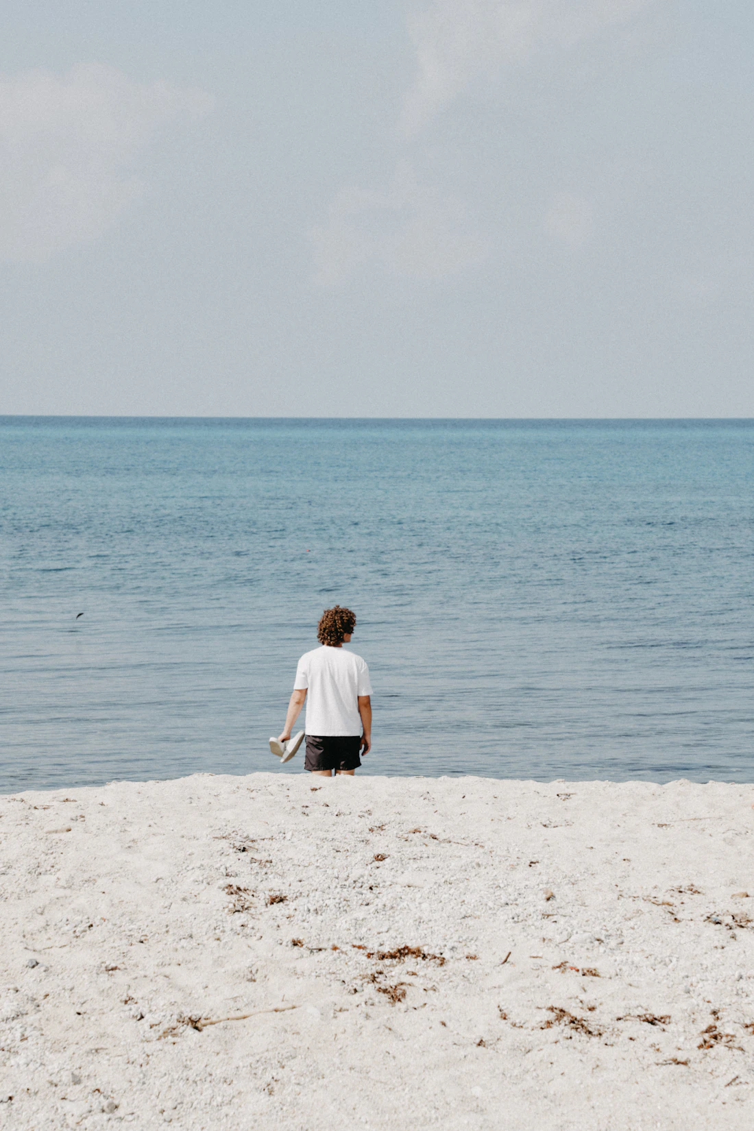 Person an einem ruhigen Strand als Symbol für Urlaub und Ausnahmen