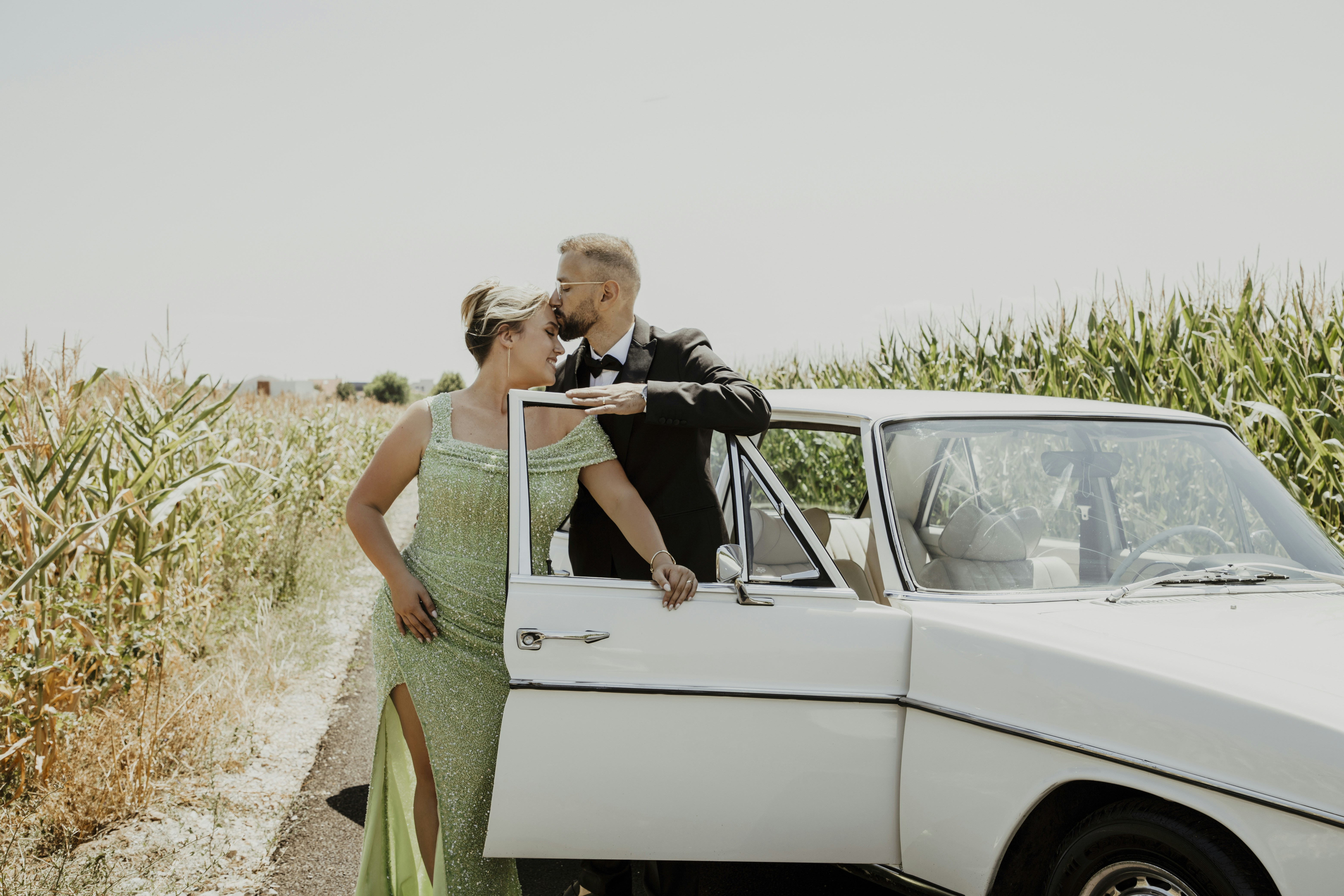 Couple standing by a vintage car in a field