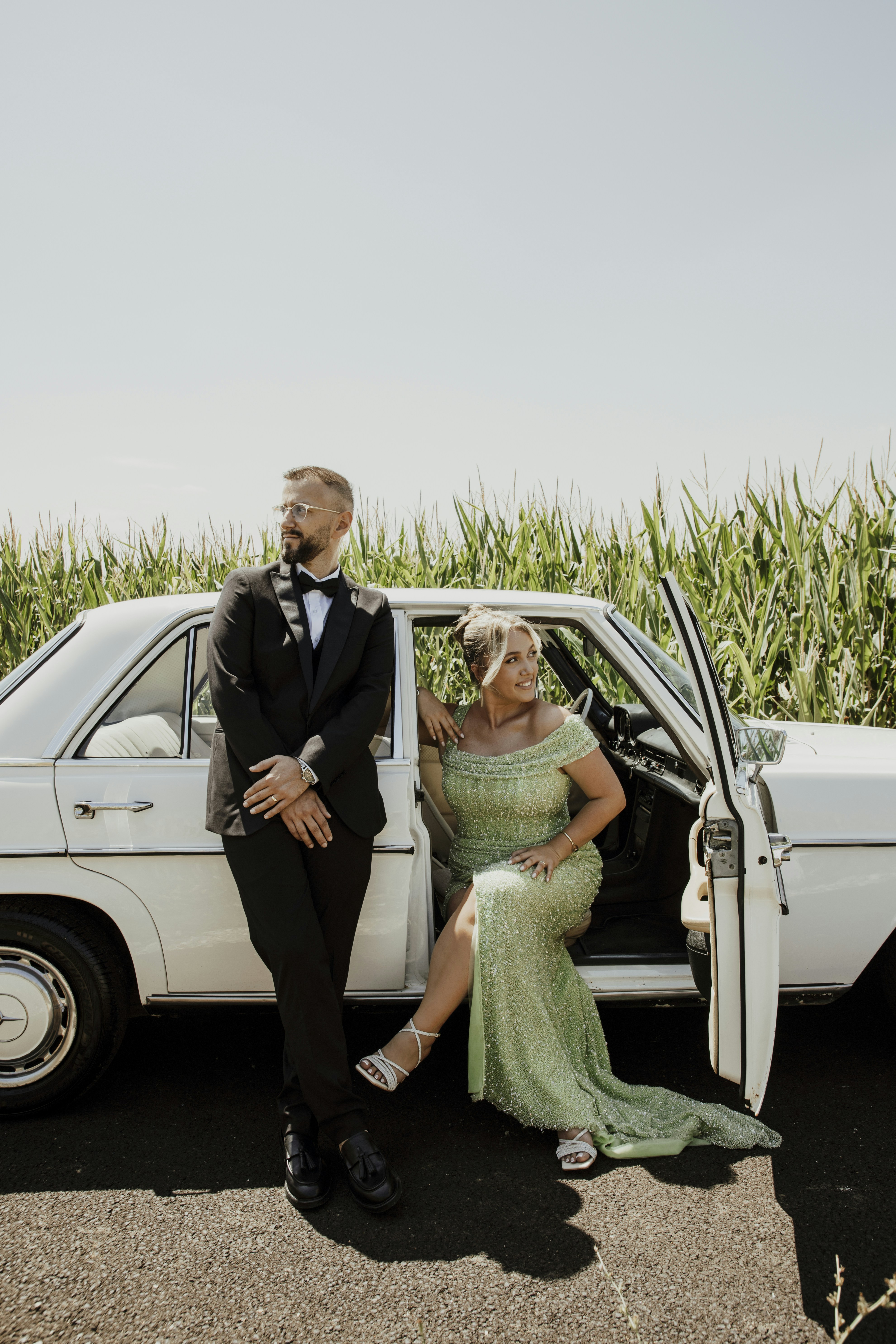 Couple in formal wear by a classic car