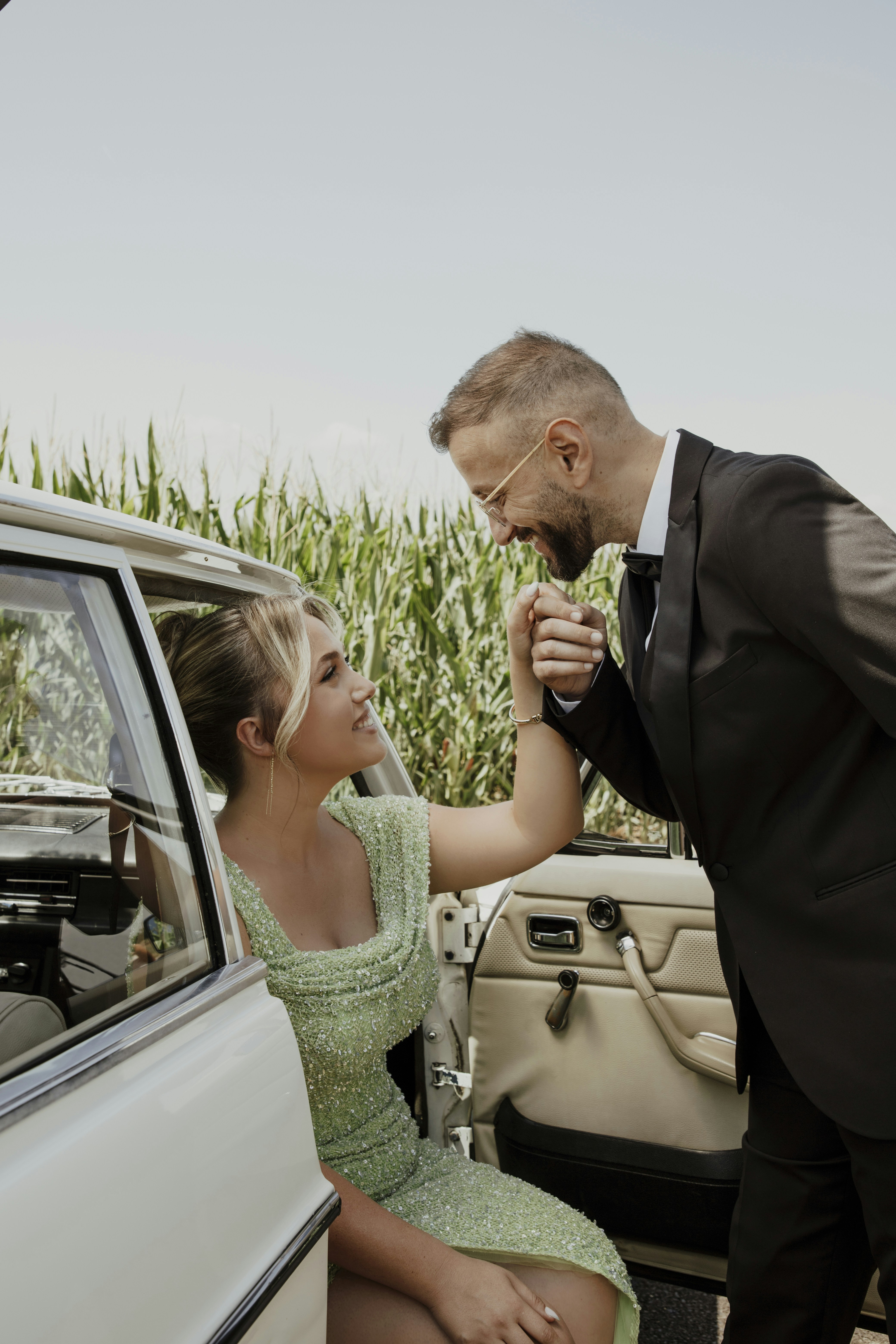 Couple in vintage car with cornfield background