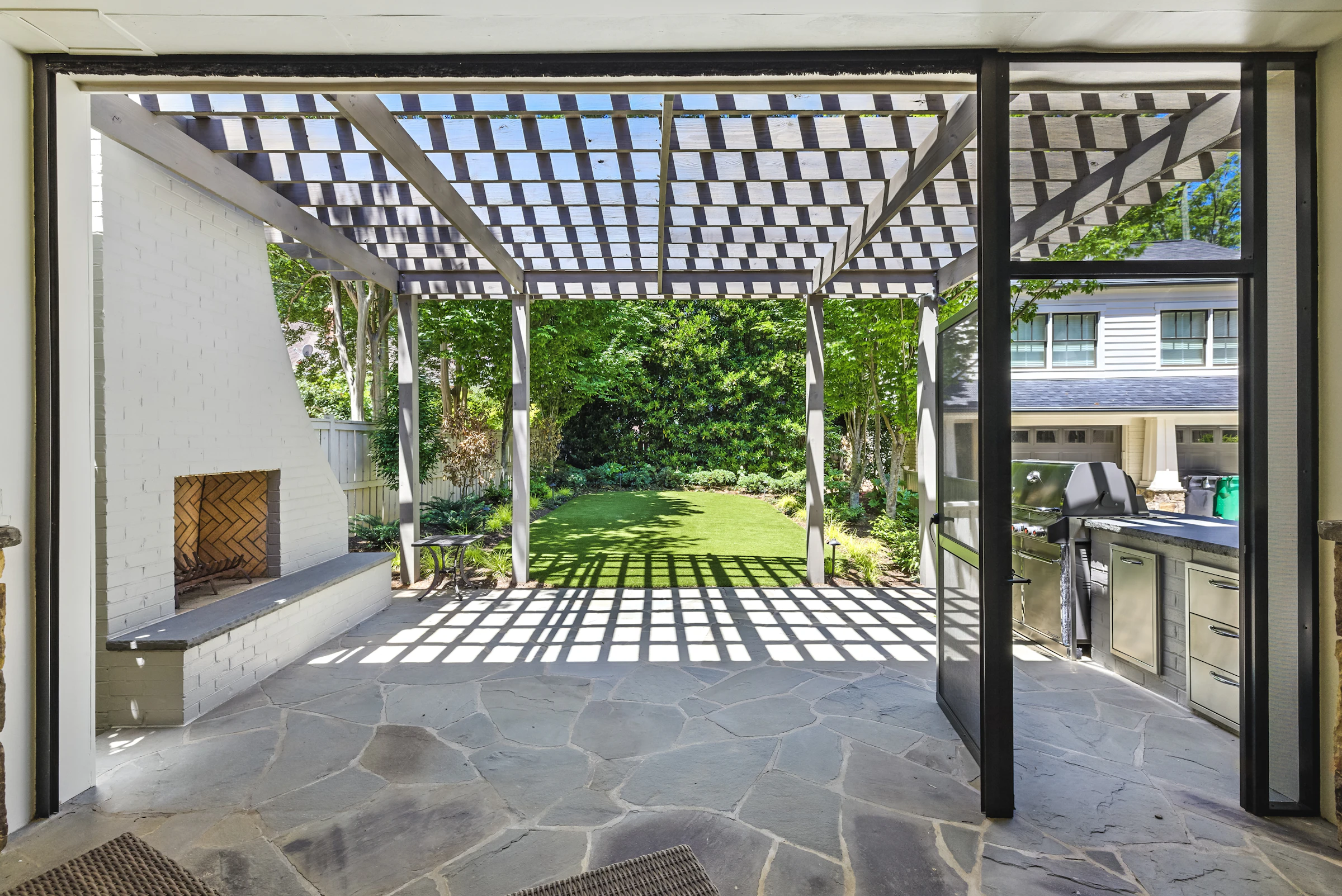 Modern patio with pergola, fireplace, and outdoor kitchen