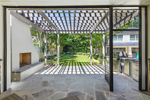 Completed patio with pergola, fireplace, and outdoor kitchen