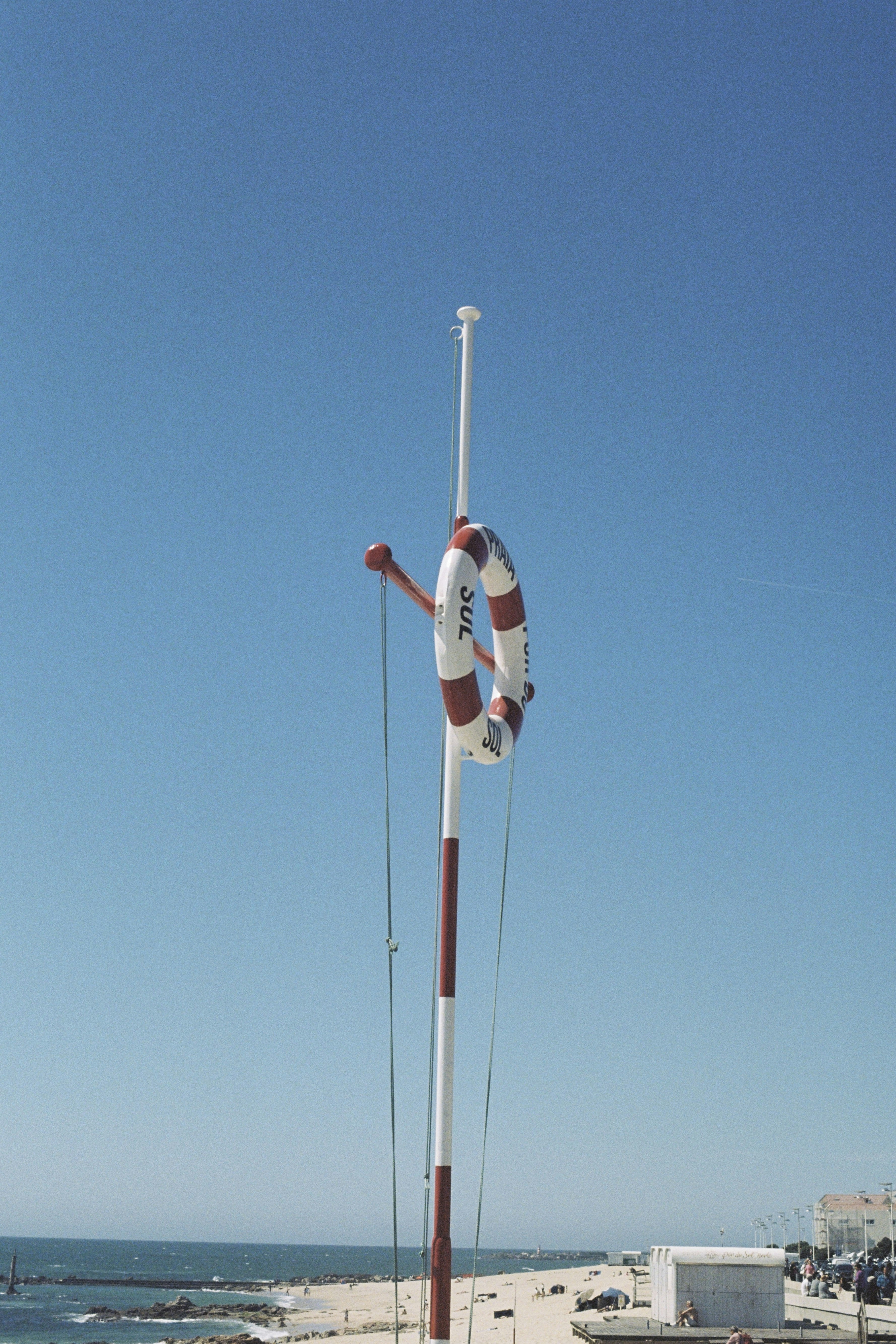 Life preserver hangs on a pole against blue sky