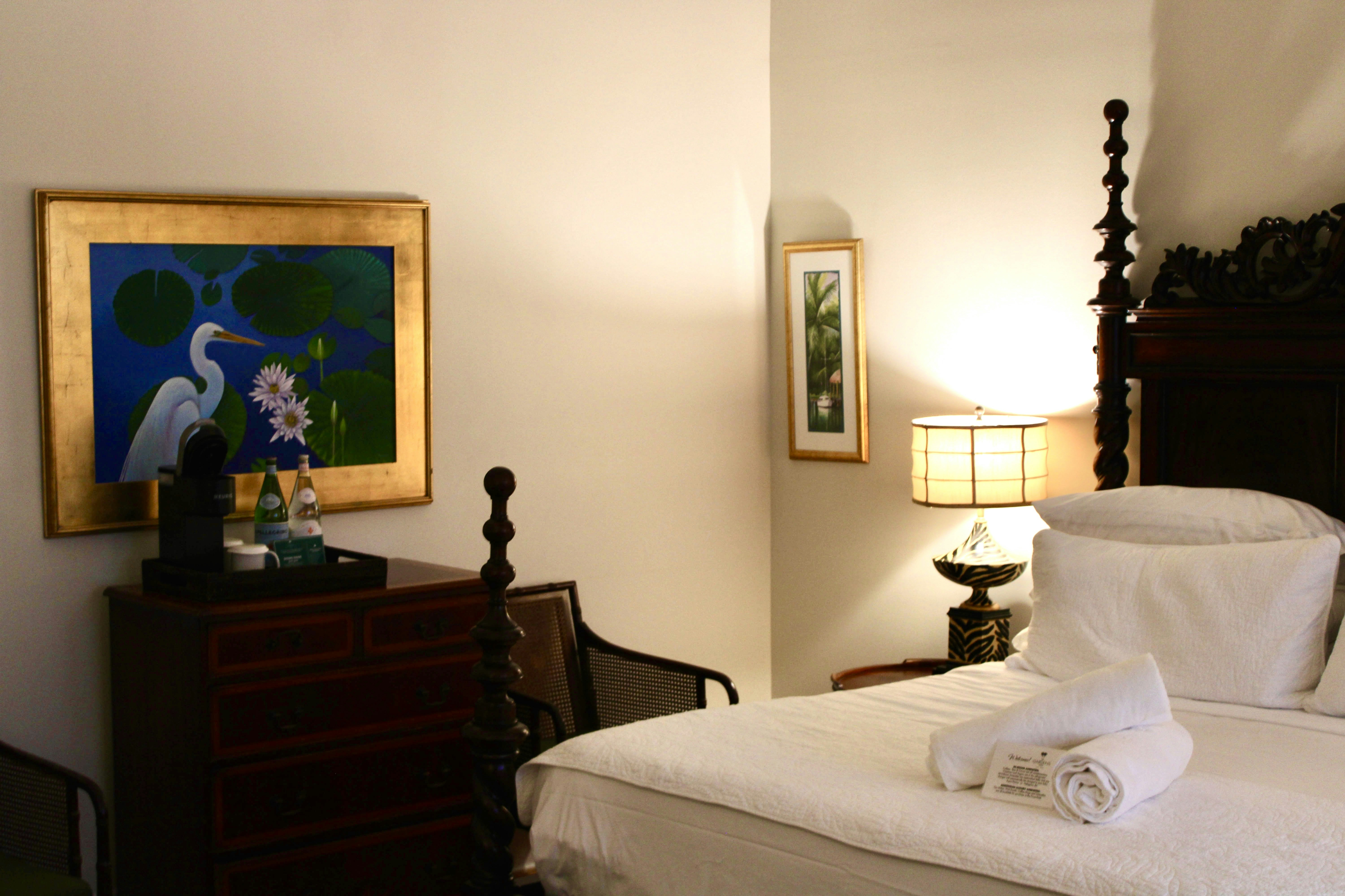 A bedroom with a large bed and artwork