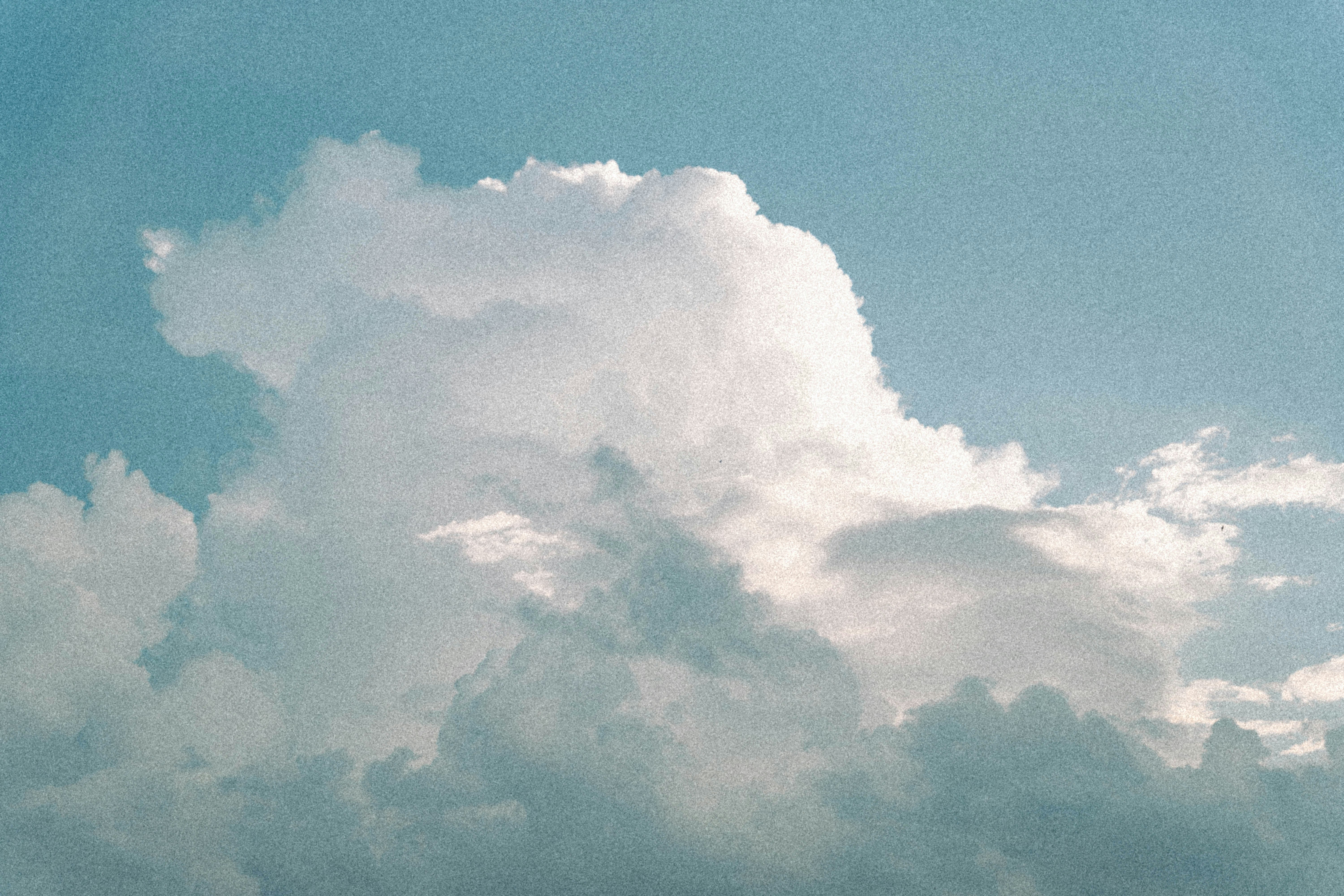 Fluffy white clouds against a bright blue sky