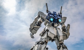 Giant white robot with blue glowing eyes against sky