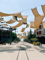 Street with fabric shades and buildings under clear sky