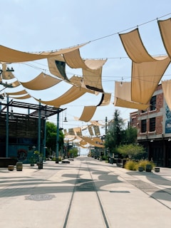 Street with fabric shades and buildings under clear sky