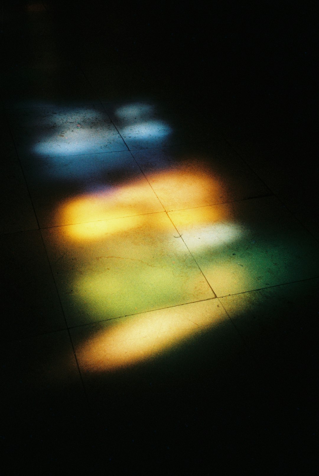 colorful-light-patterns-on-a-dark-tiled-floor-PkLxHkdR8Bo.png