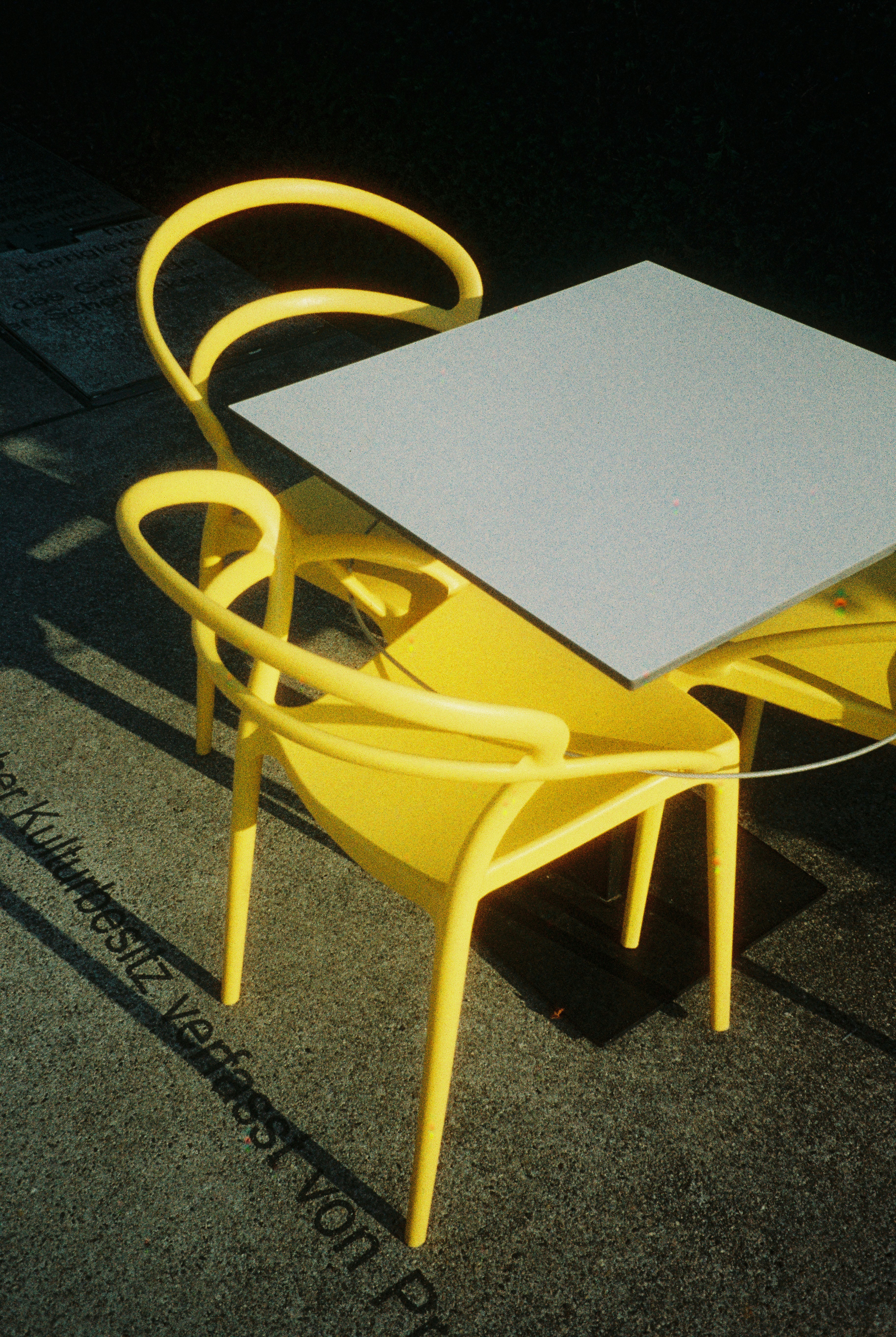 Two yellow chairs and a table outdoors