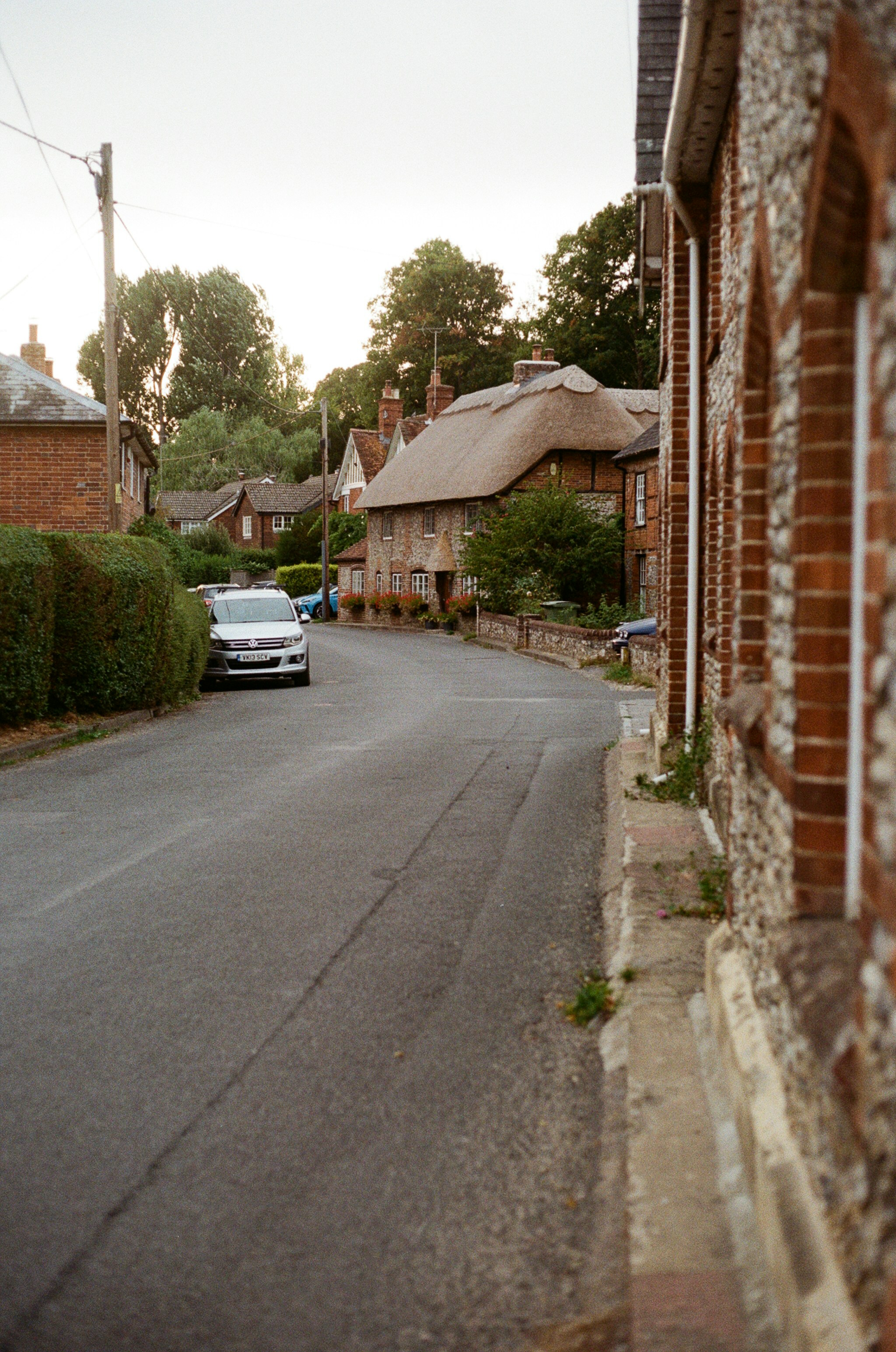 Quiet village street with traditional houses and car.