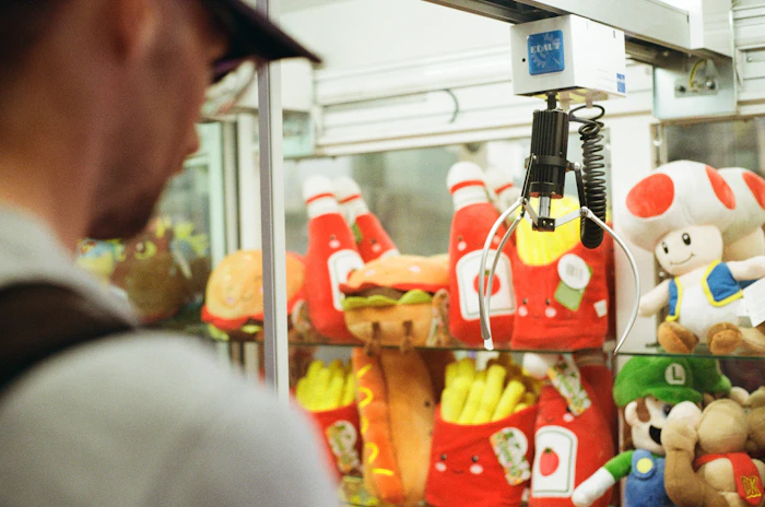 Person playing a claw machine filled with plush toys