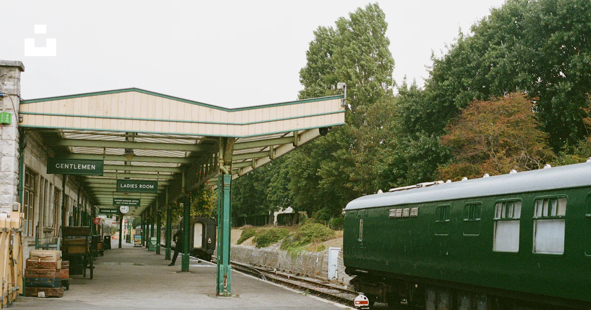 Green train carriage at a covered station platform photo – Free Film ...