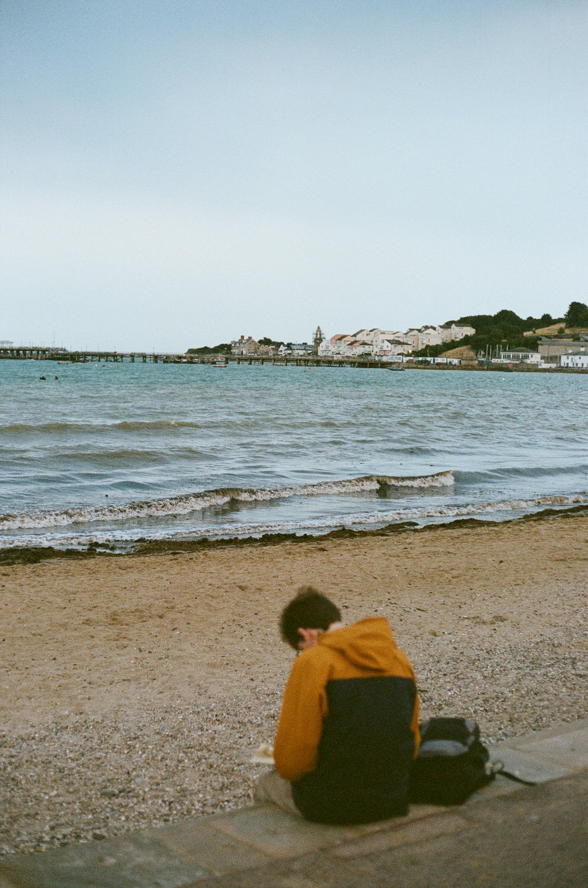 Person sitting on a wall by the sea