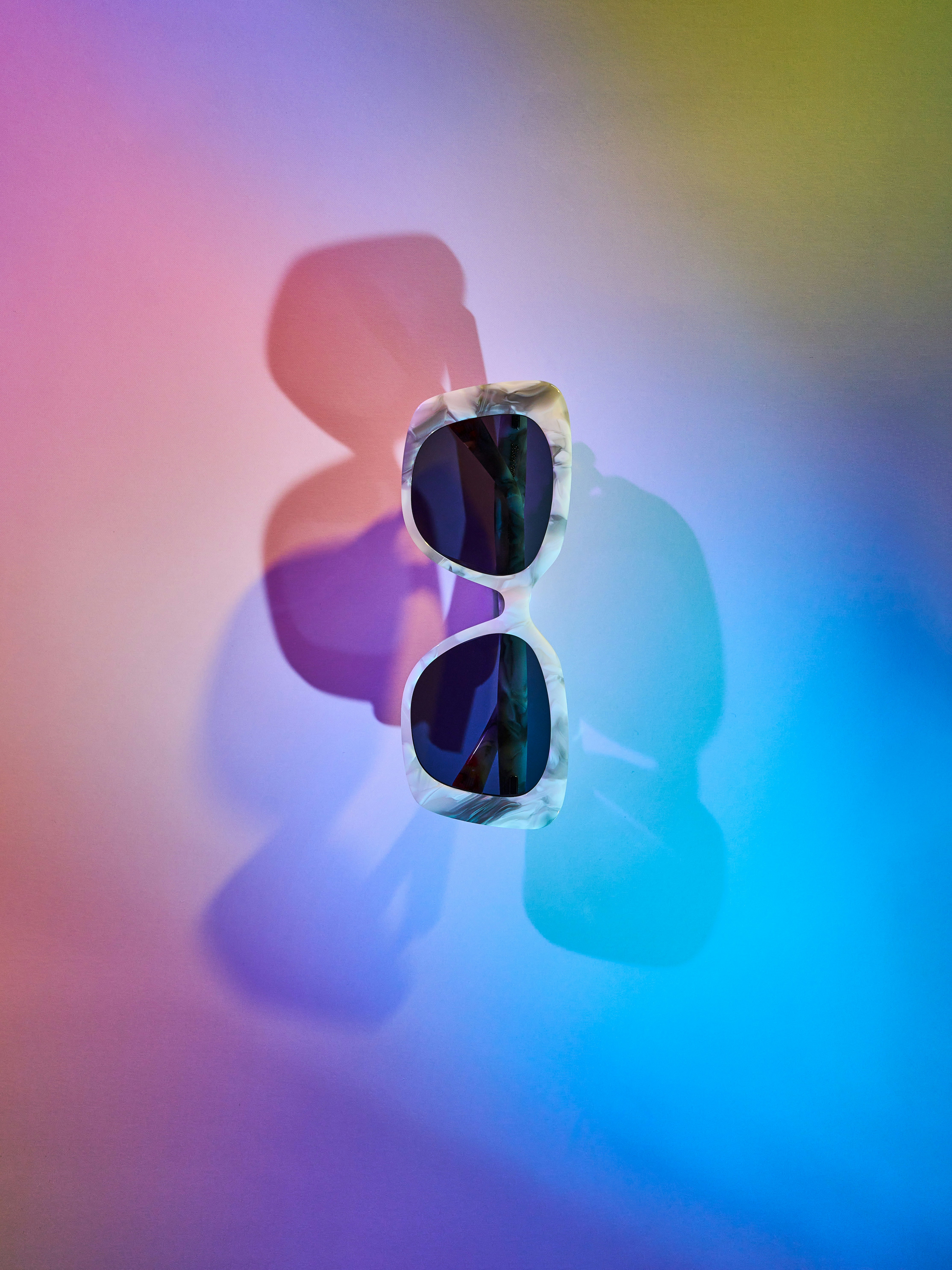 Sunglasses on a colorful, reflective surface
