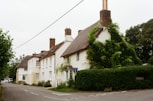 Row of white cottages with thatched roofs