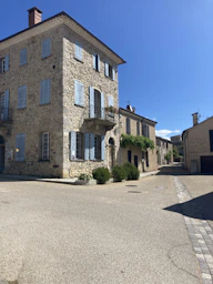 Stone building with blue shutters on sunny day