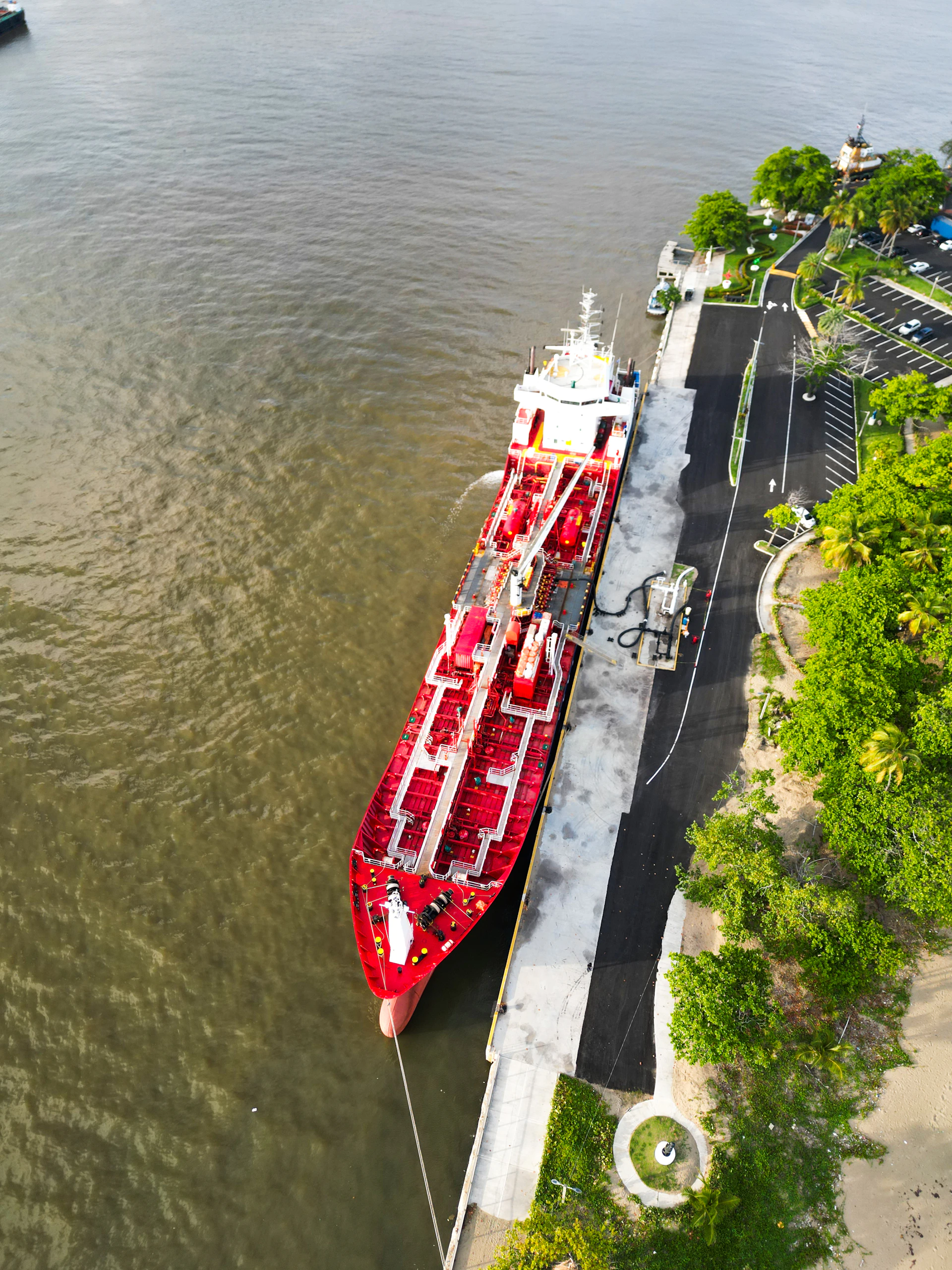 Large red tanker ship docked at a pier