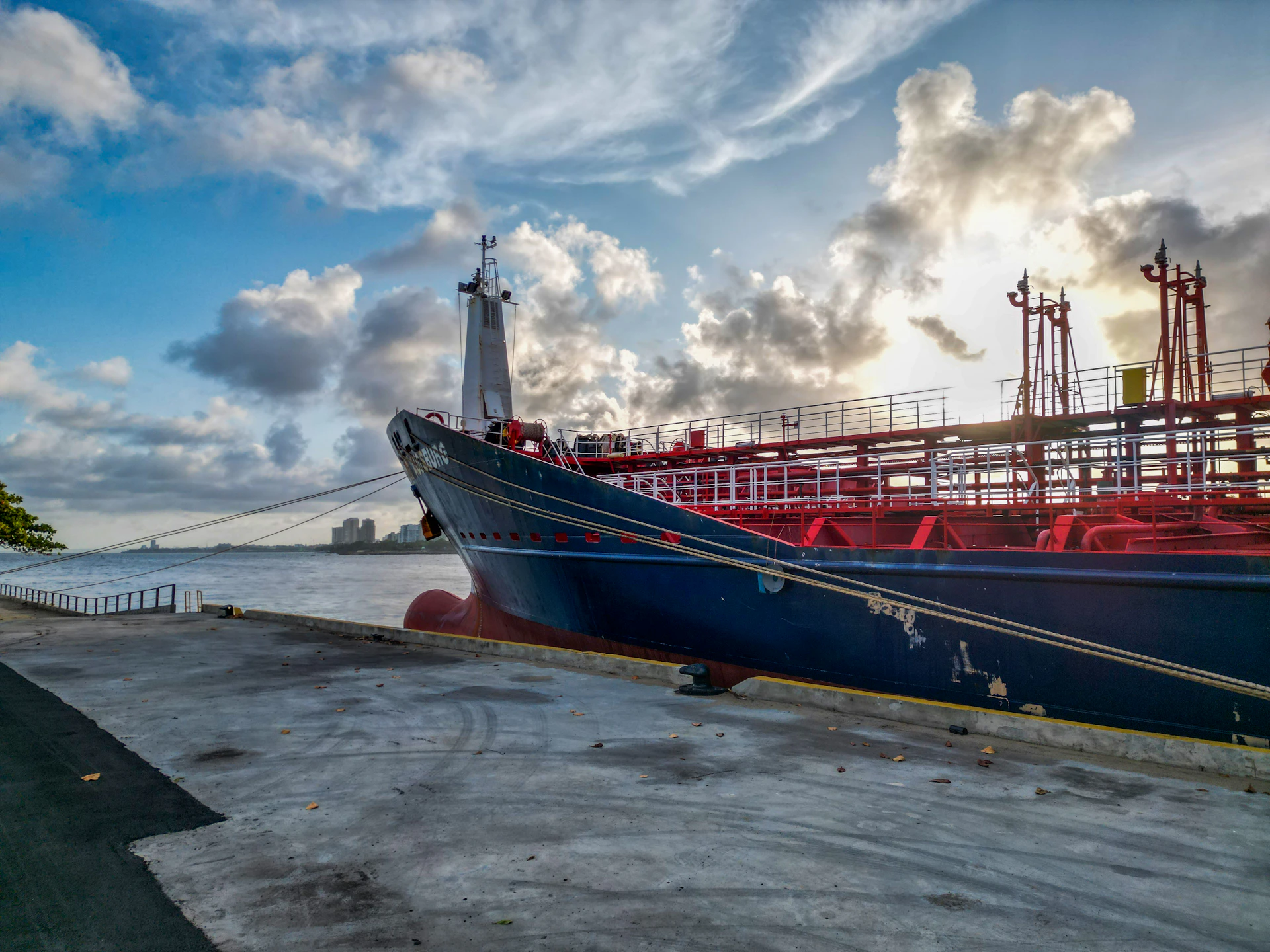 Large cargo ship docked at a pier during sunset