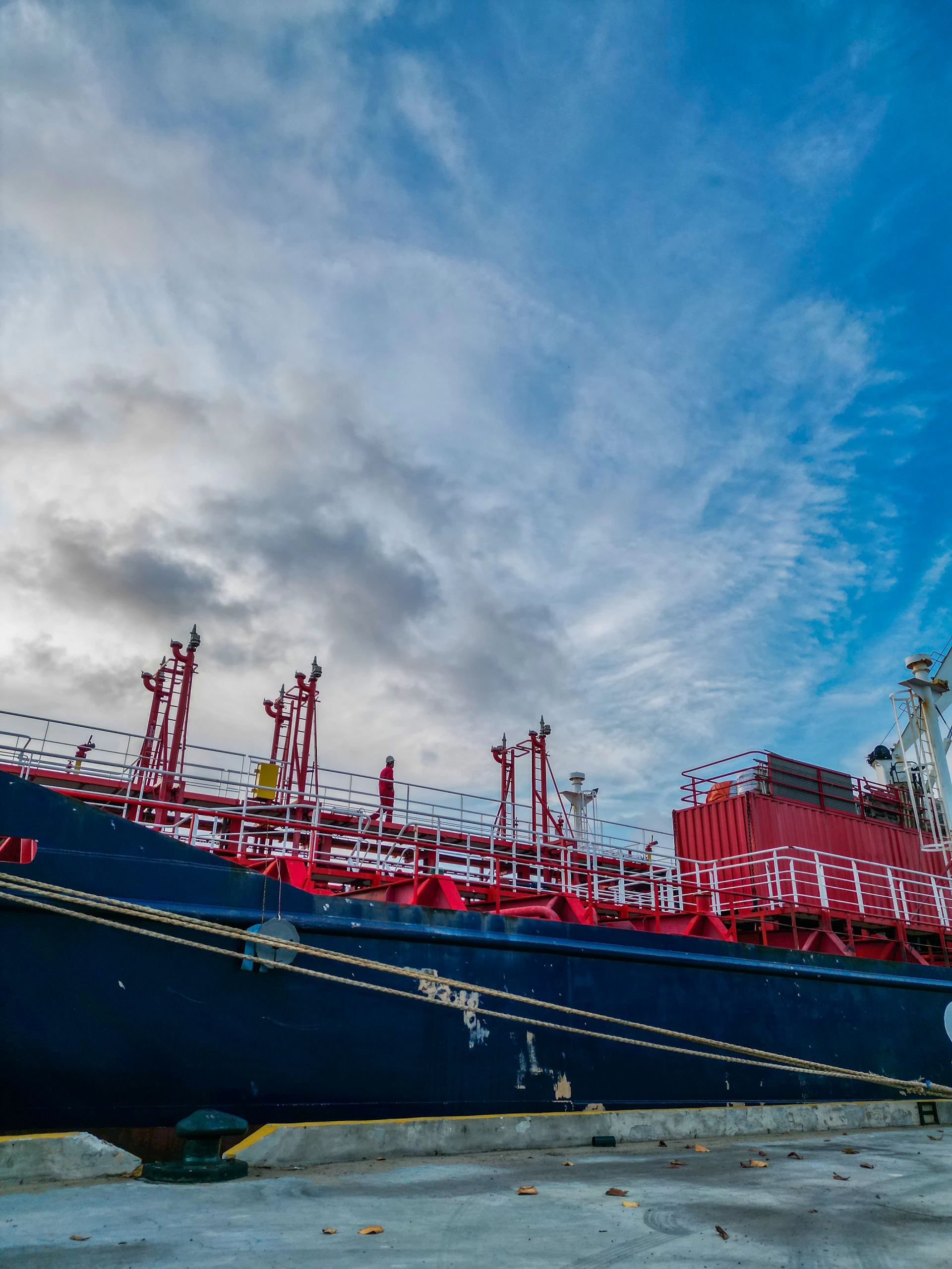 Large cargo ship docked at a harbor under a cloudy sky