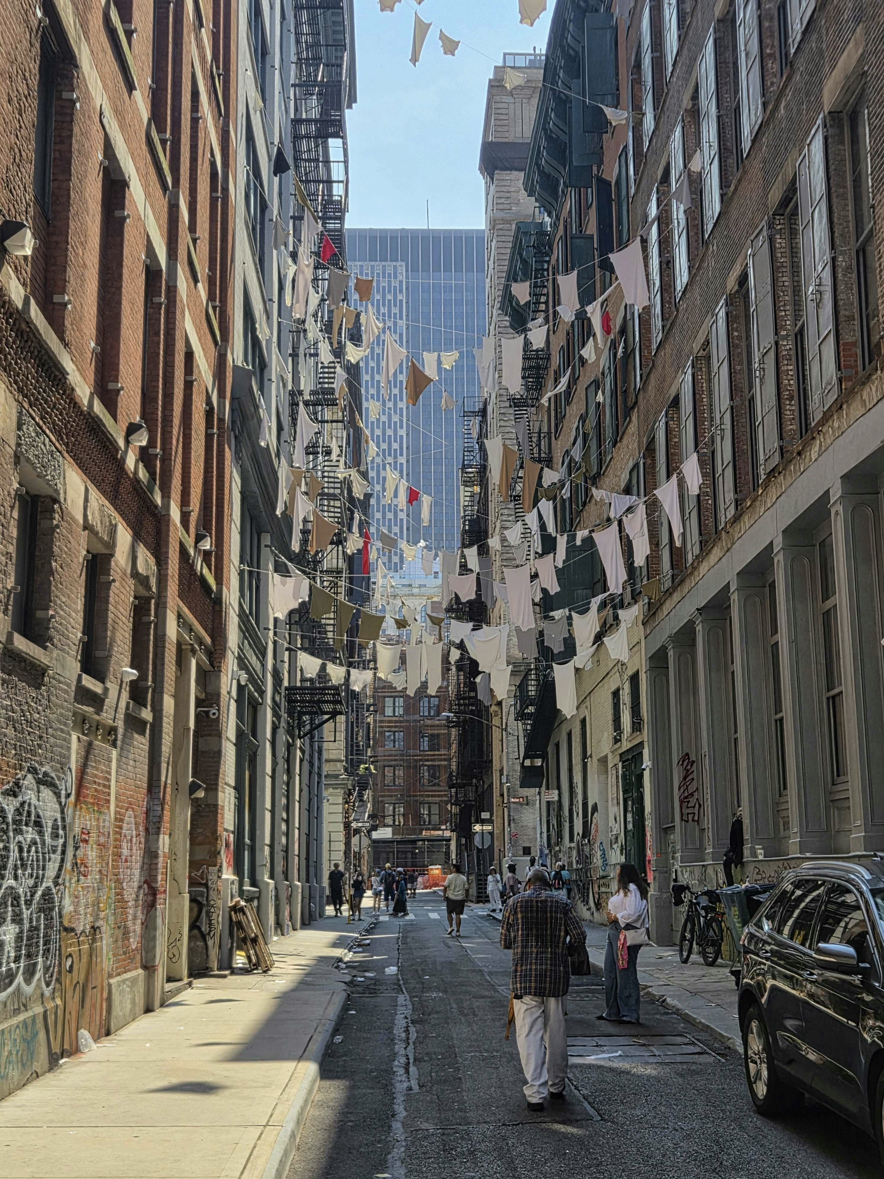 Clothes hang between buildings on city street.