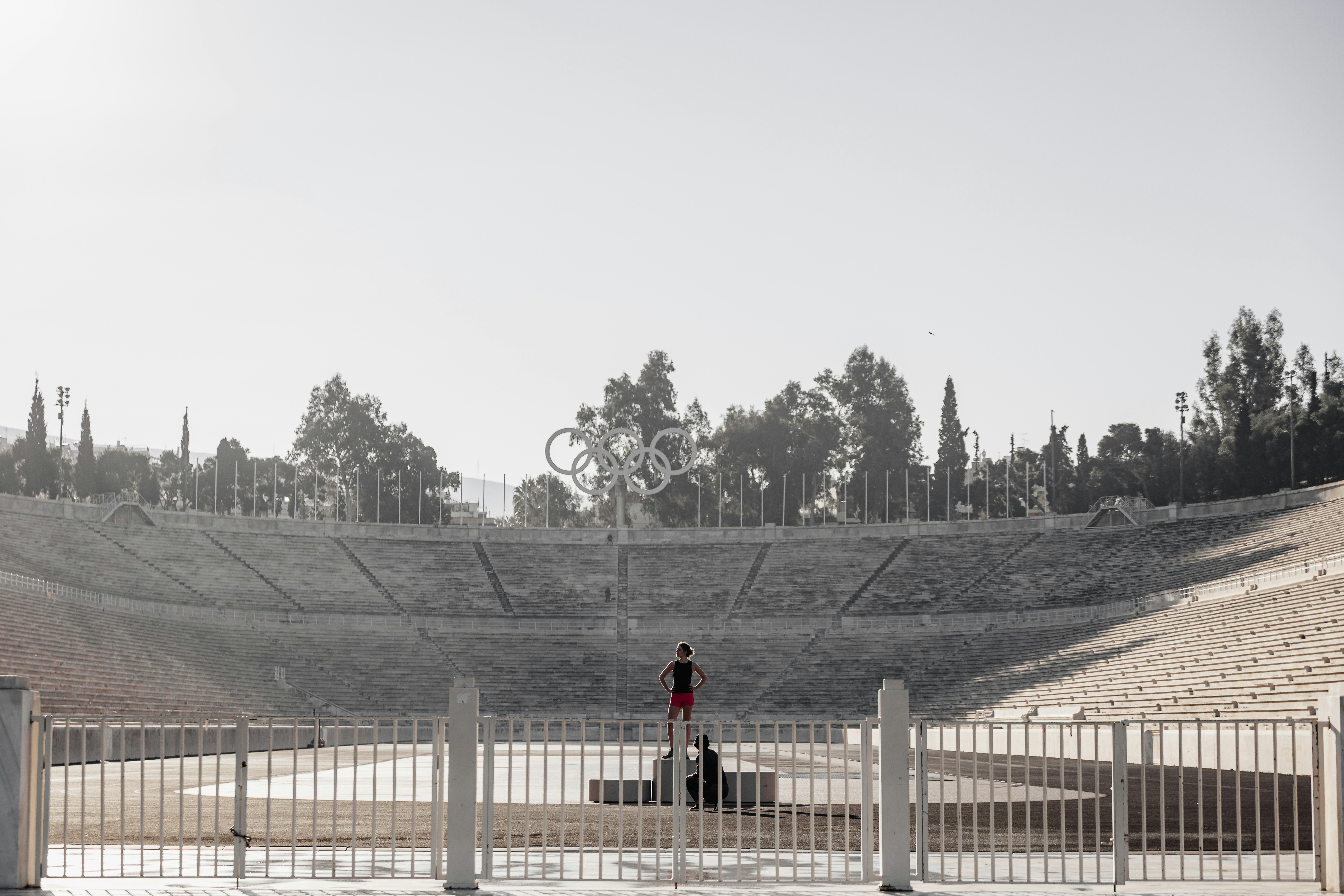 Athlete standing in ancient stadium at sunrise