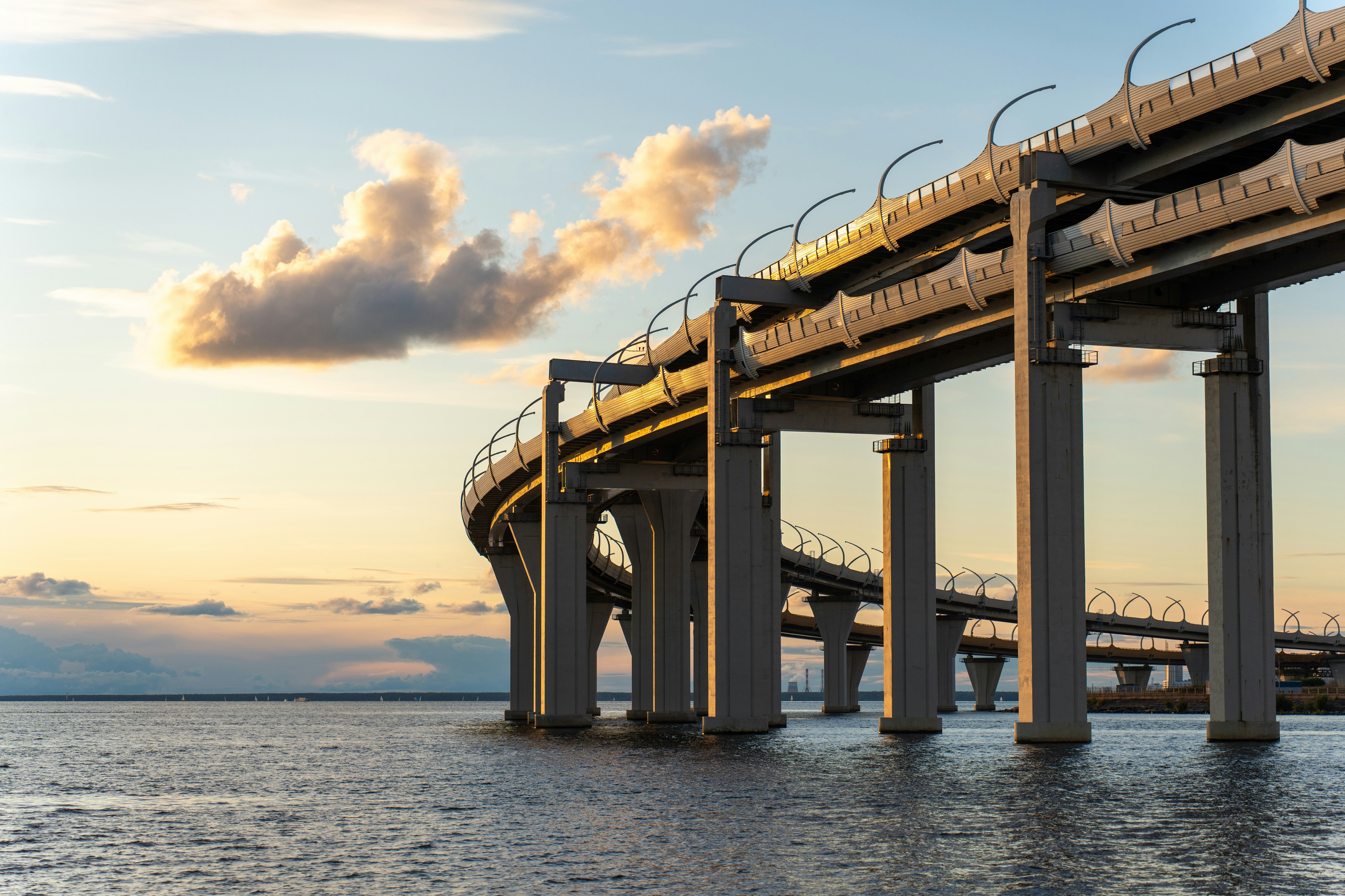Moderne Hochstraße über ruhigem Wasser bei Sonnenuntergang
