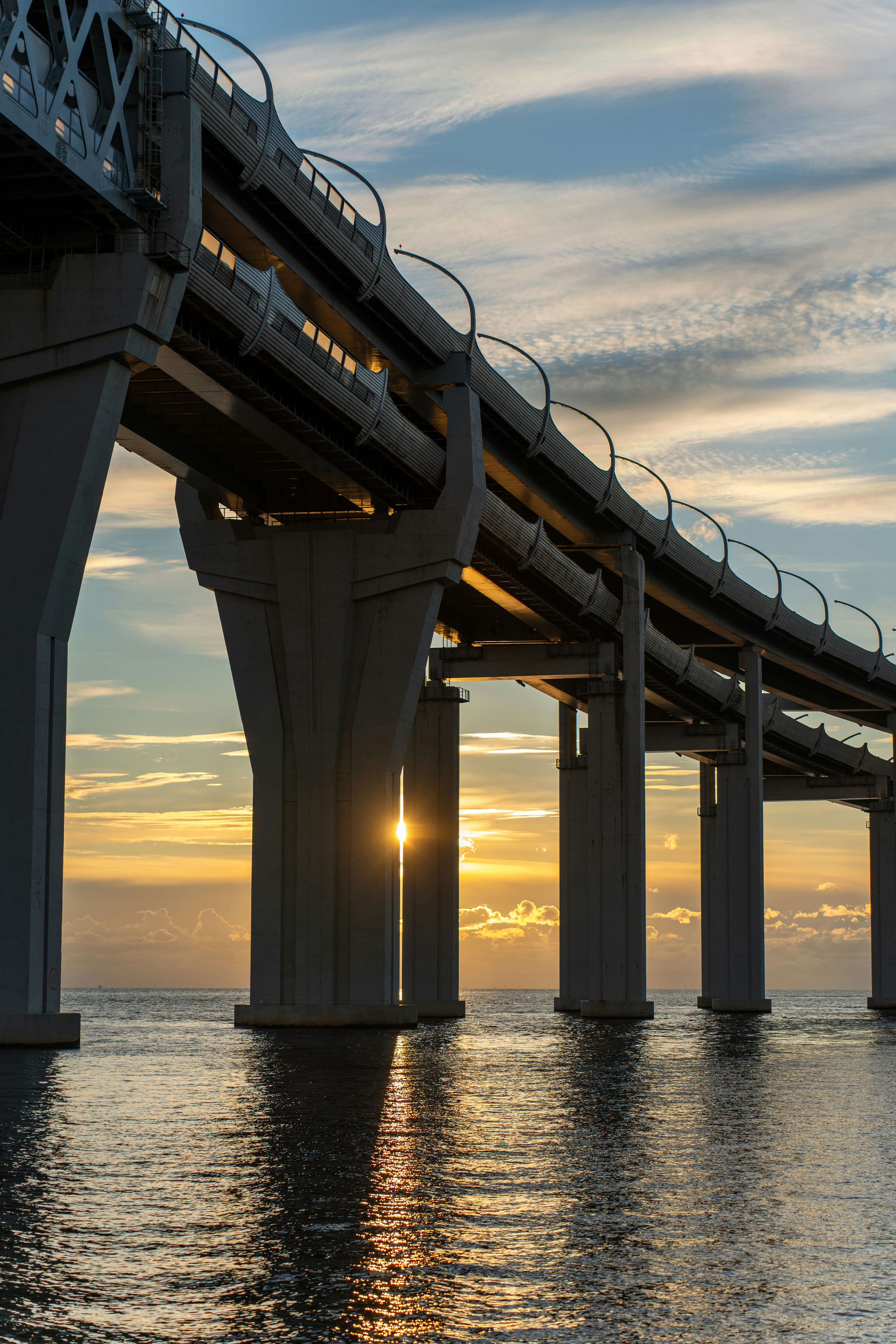 Moderne Brücke über ruhiges Wasser bei Sonnenuntergang