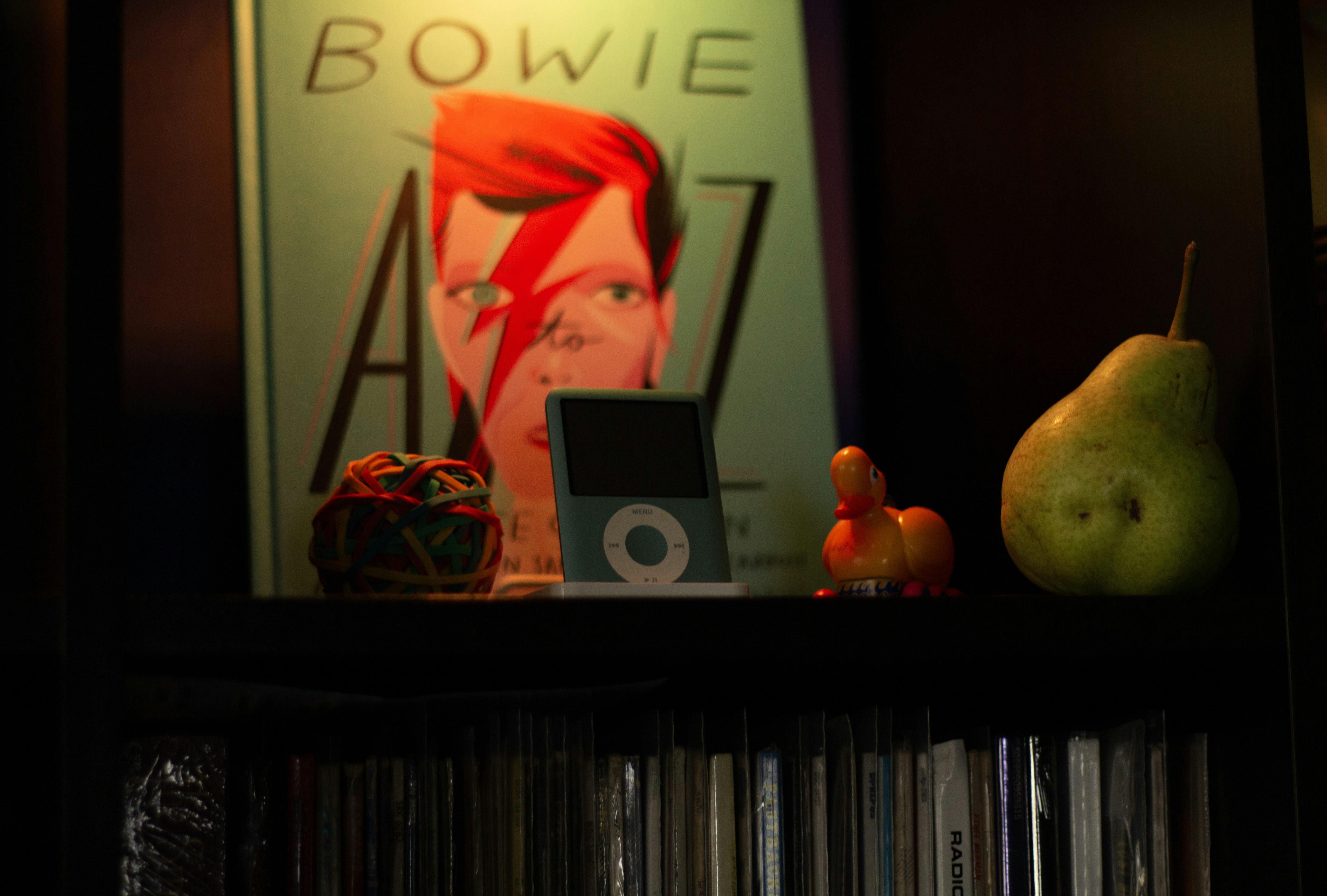 David bowie book with iPod and pear on shelf