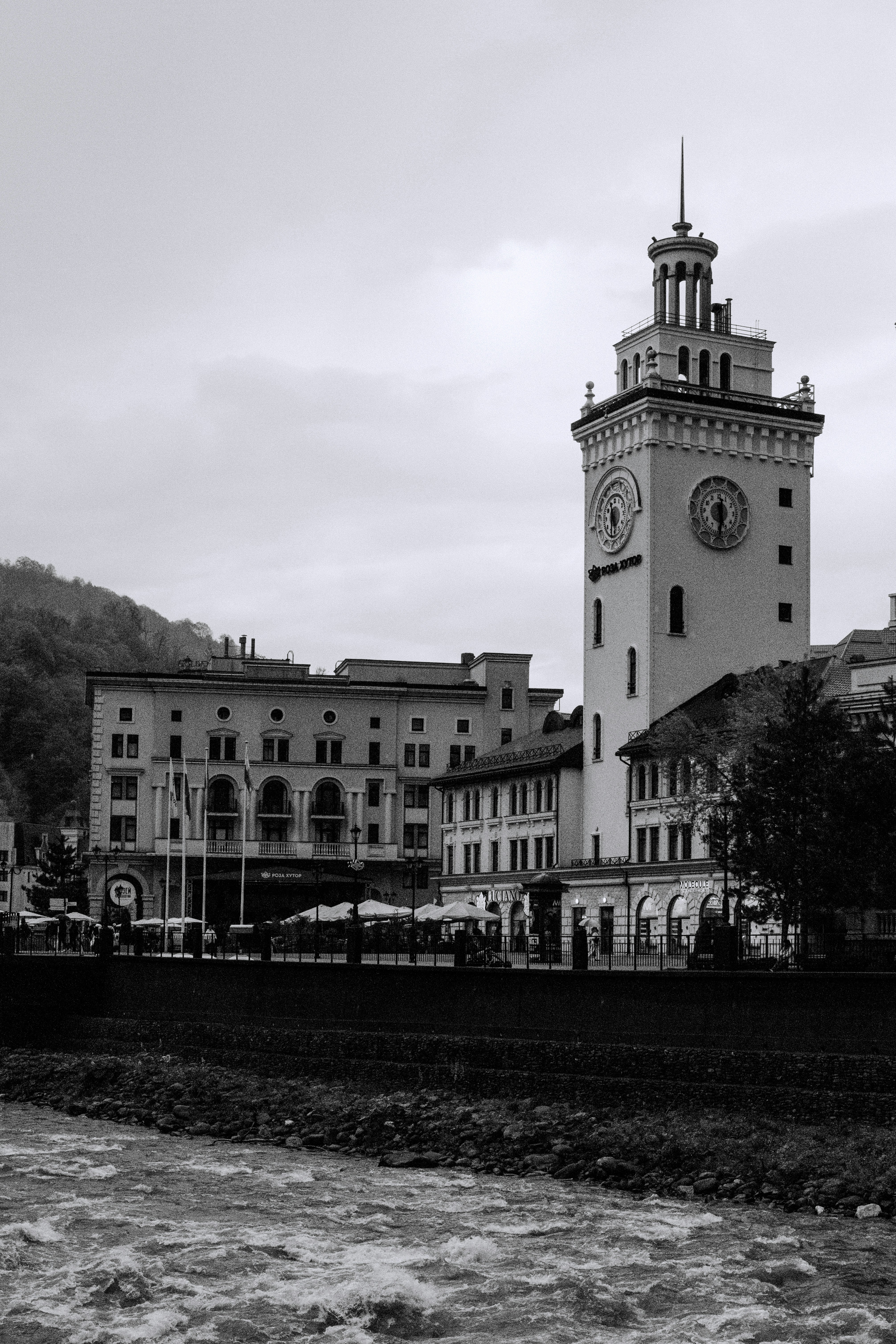 Clock tower building beside a flowing river.