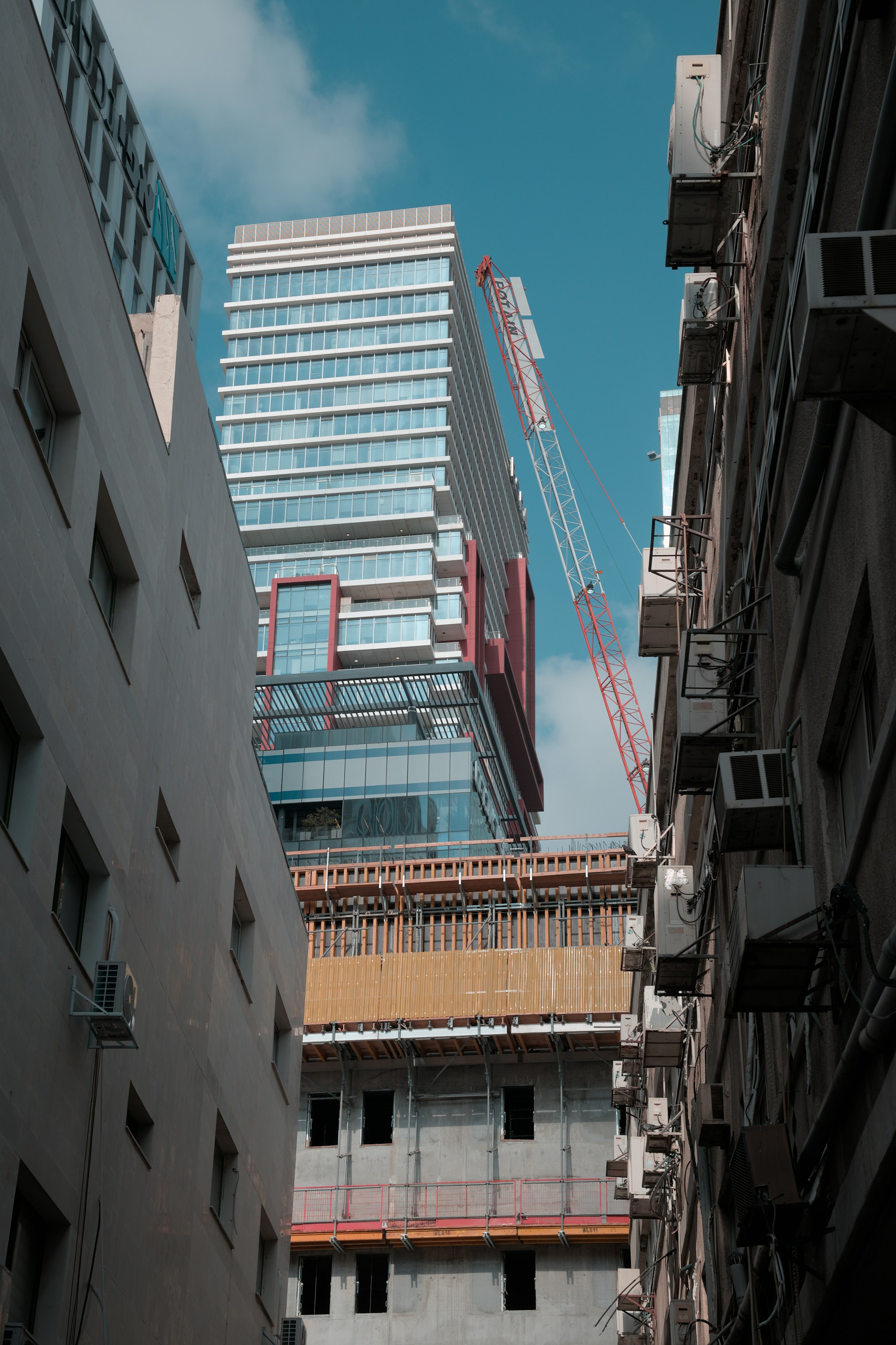 Modern building under construction with a crane.