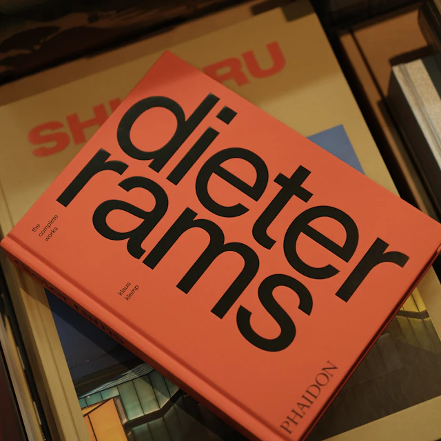 Orange book titled Dieter Rams resting on top of a stack of other books
