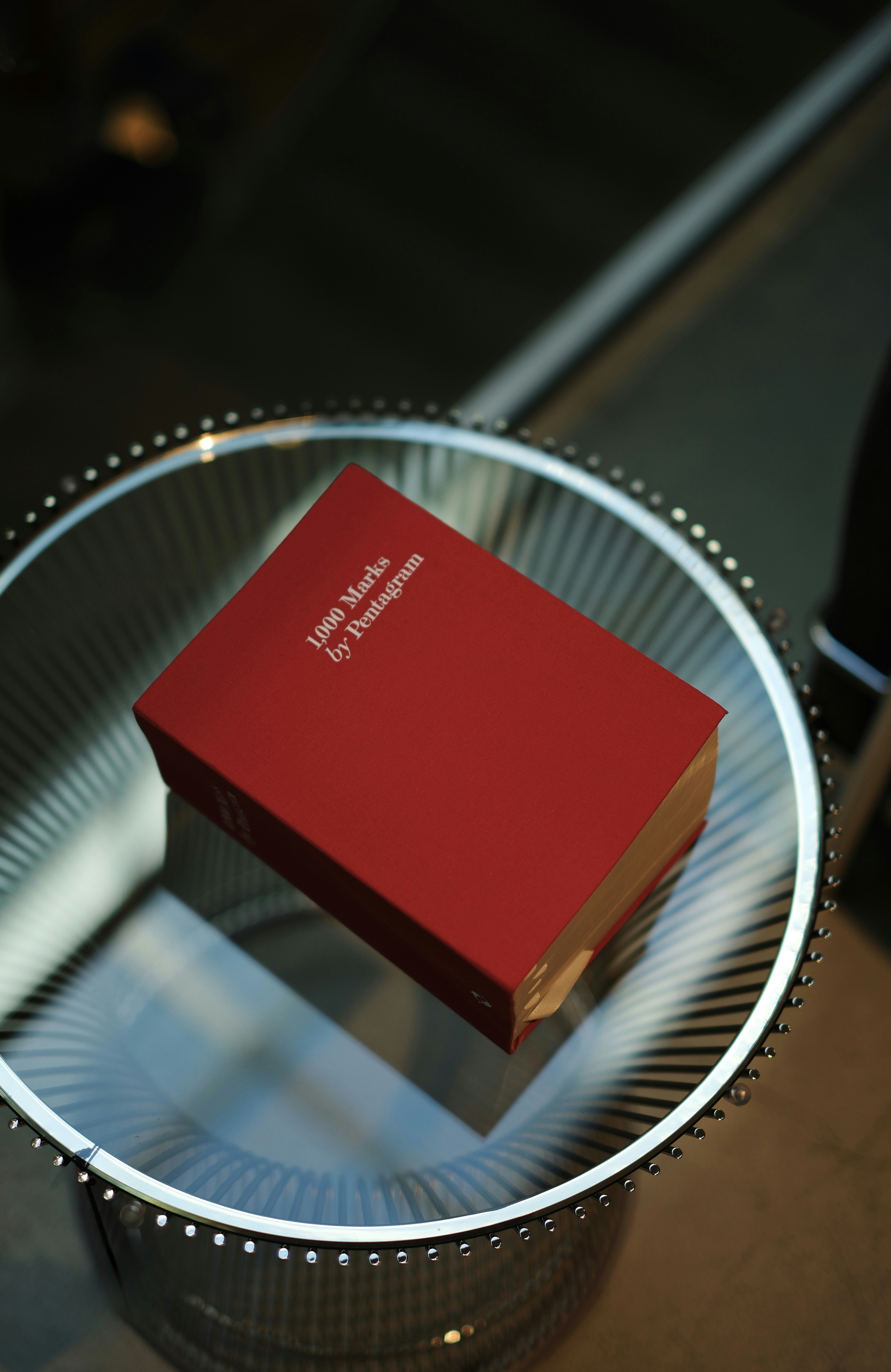 Livro vermelho intitulado "1000 marcas" por pentagrama.