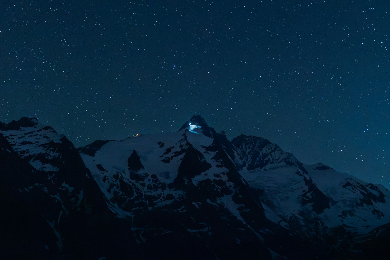 Snowy mountains under a starry night sky