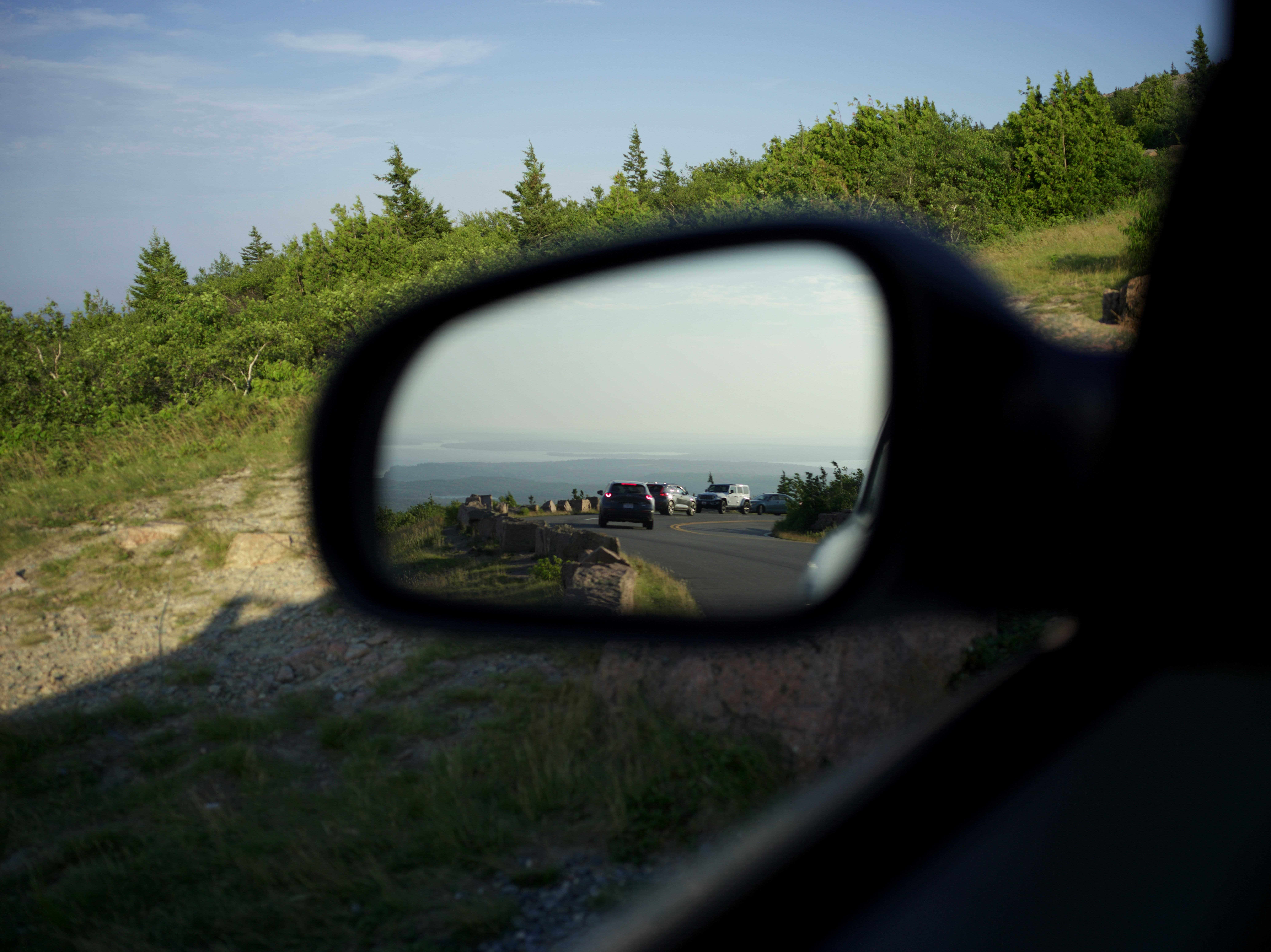 Cars reflected in a side mirror with landscape background landscape