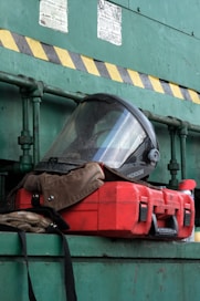 Protective helmet and red case on shelf