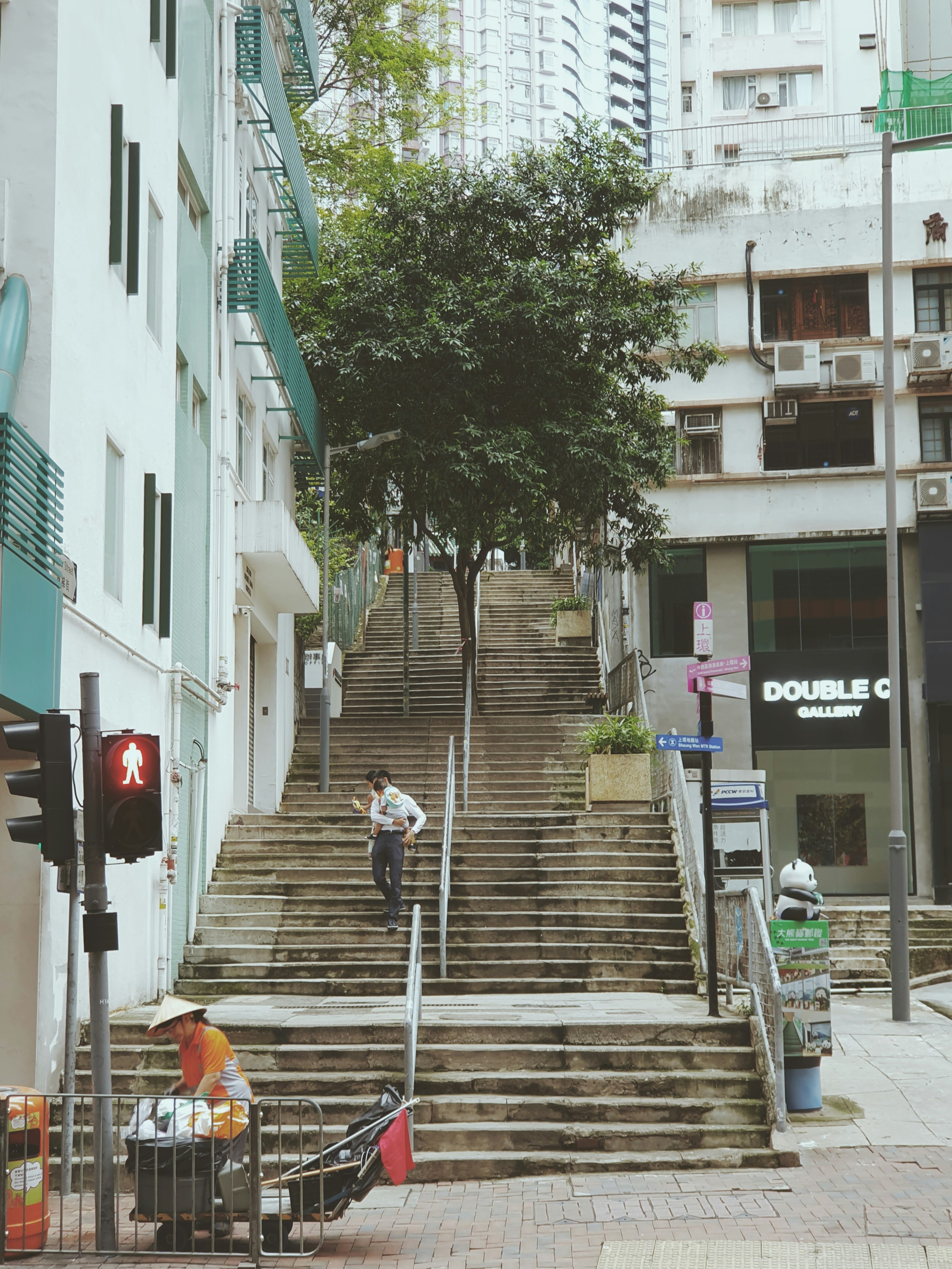 Des gens montent un large escalier en béton dans une ville.